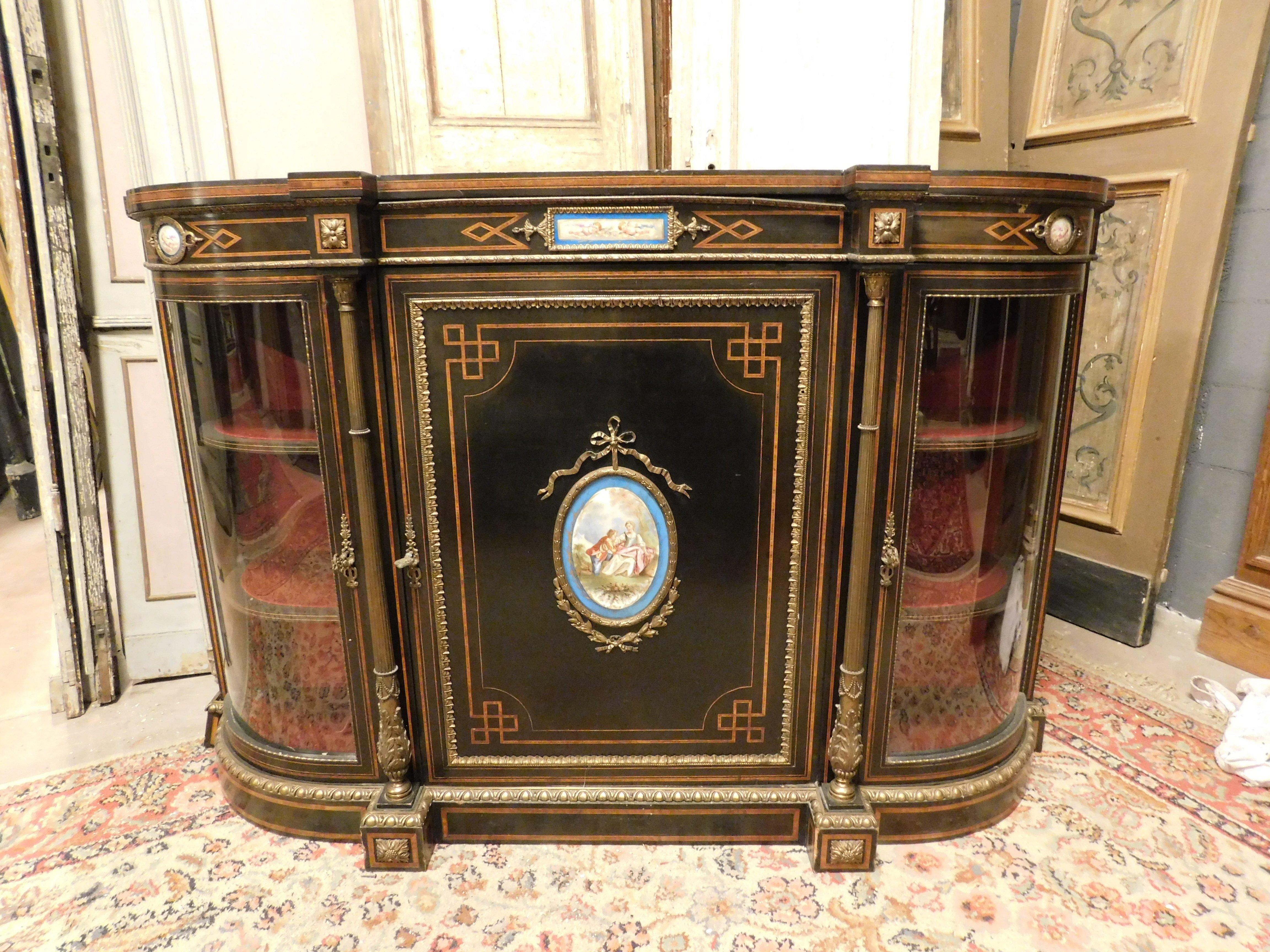 Antique sideboard, Servant in ebonized wood, composed of curved side glass doors with red fabric interior, central door with bar cabinet-type shelves, embellished with gilded bronzes and porcelain plaques by Serves, depicting gallant scenes, from