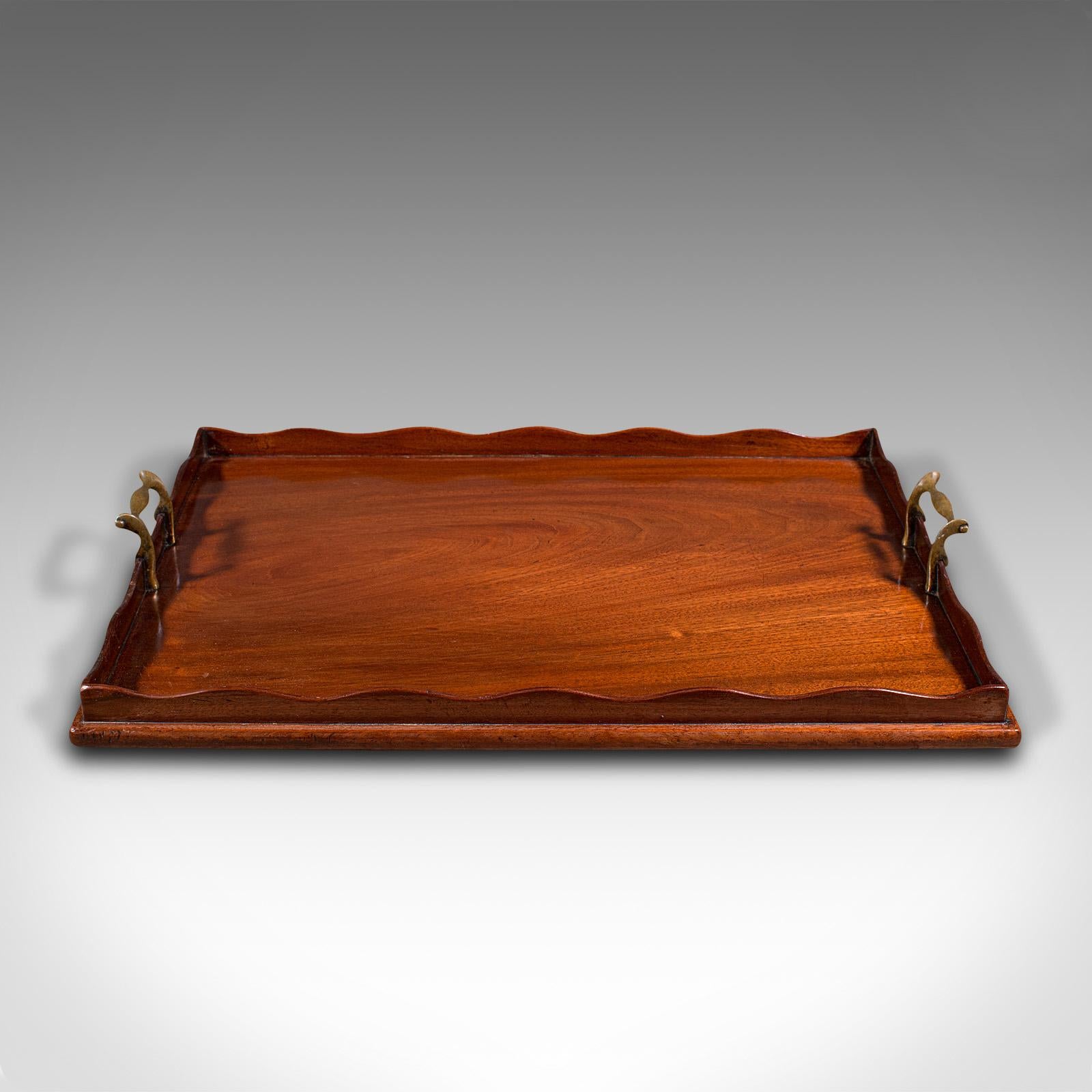 This is an antique butler's serving tray. An English, mahogany and brass tray, dating to the Victorian period, circa 1870.

Present breakfast or afternoon tea with panache
Displays a desirable aged patina - service marks to base commensurate with