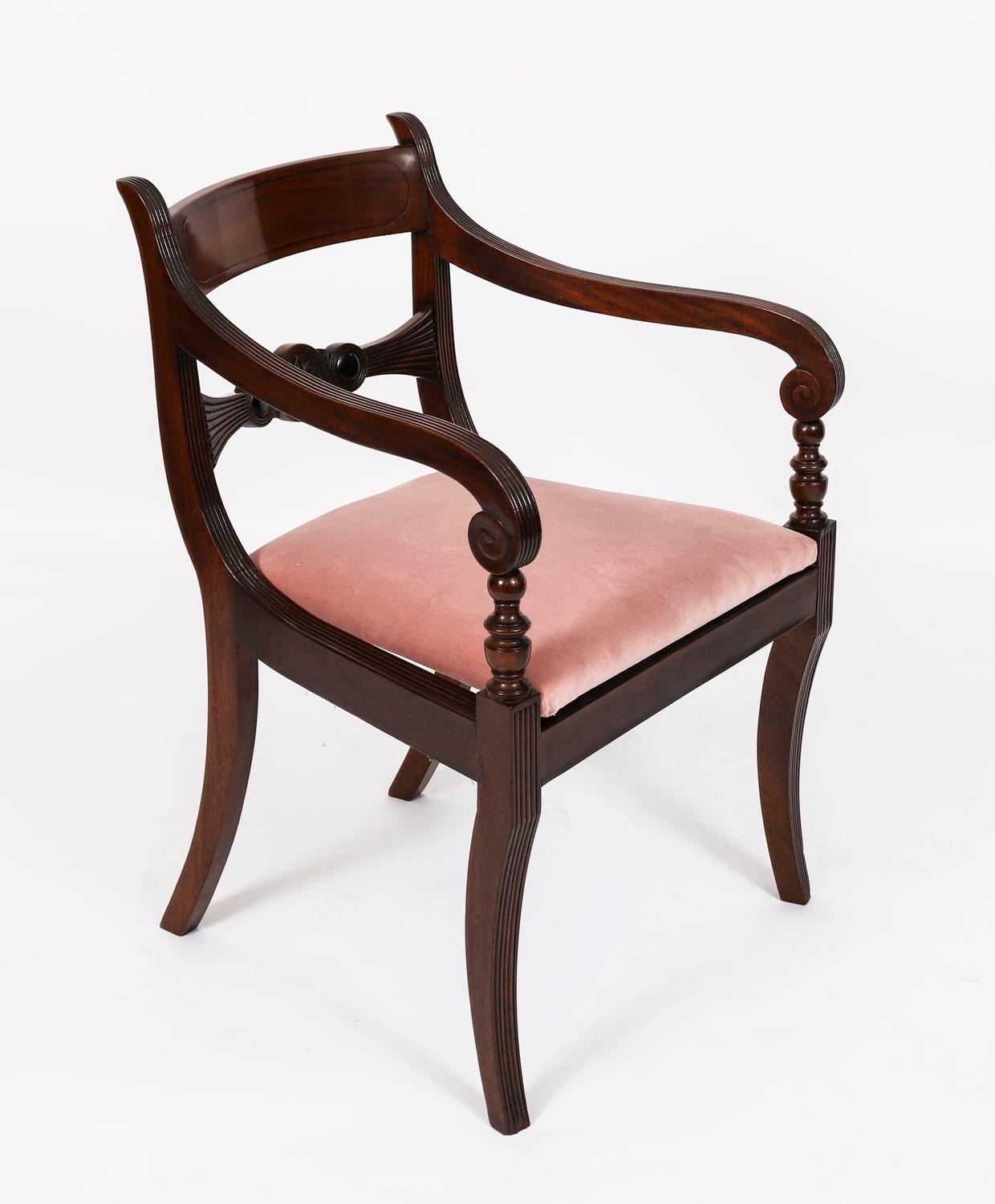 This is a fabulous set of twelve antique English Regency Period Bar Back dining chairs, Circa 1830 in date.

The set comprises ten side chairs masterfully crafted in beautiful solid flame mahogany. They each have elegant scroll carved bar backs