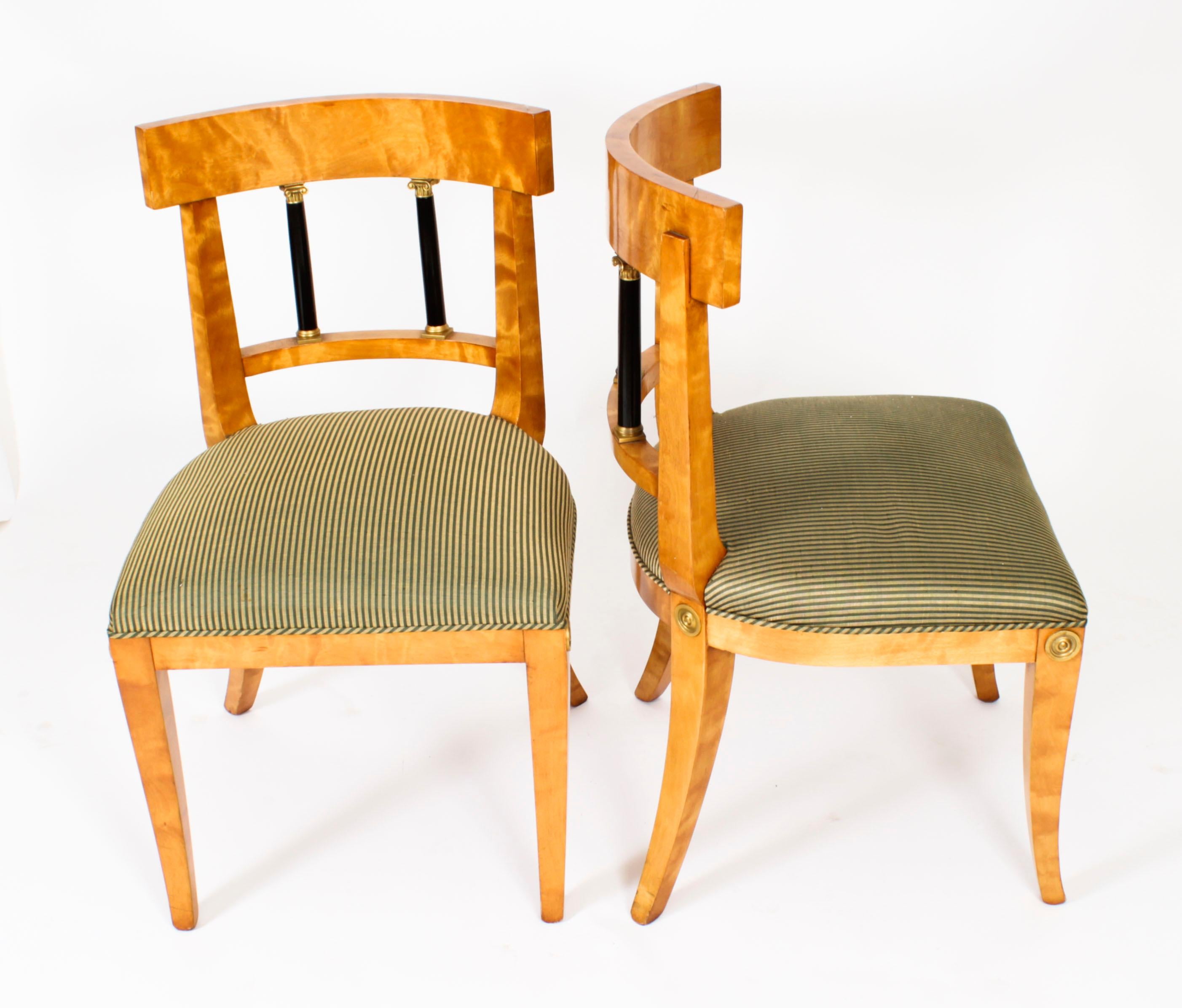 This is a fabulous and rare antique set of twelve Swedish Biedermeier birch, ormolu mounted, and ebonized dining chairs, Circa 1880 in date.

The chairs feature curved backs with ebonized Corinthian column splats and ormolu capital mounts with