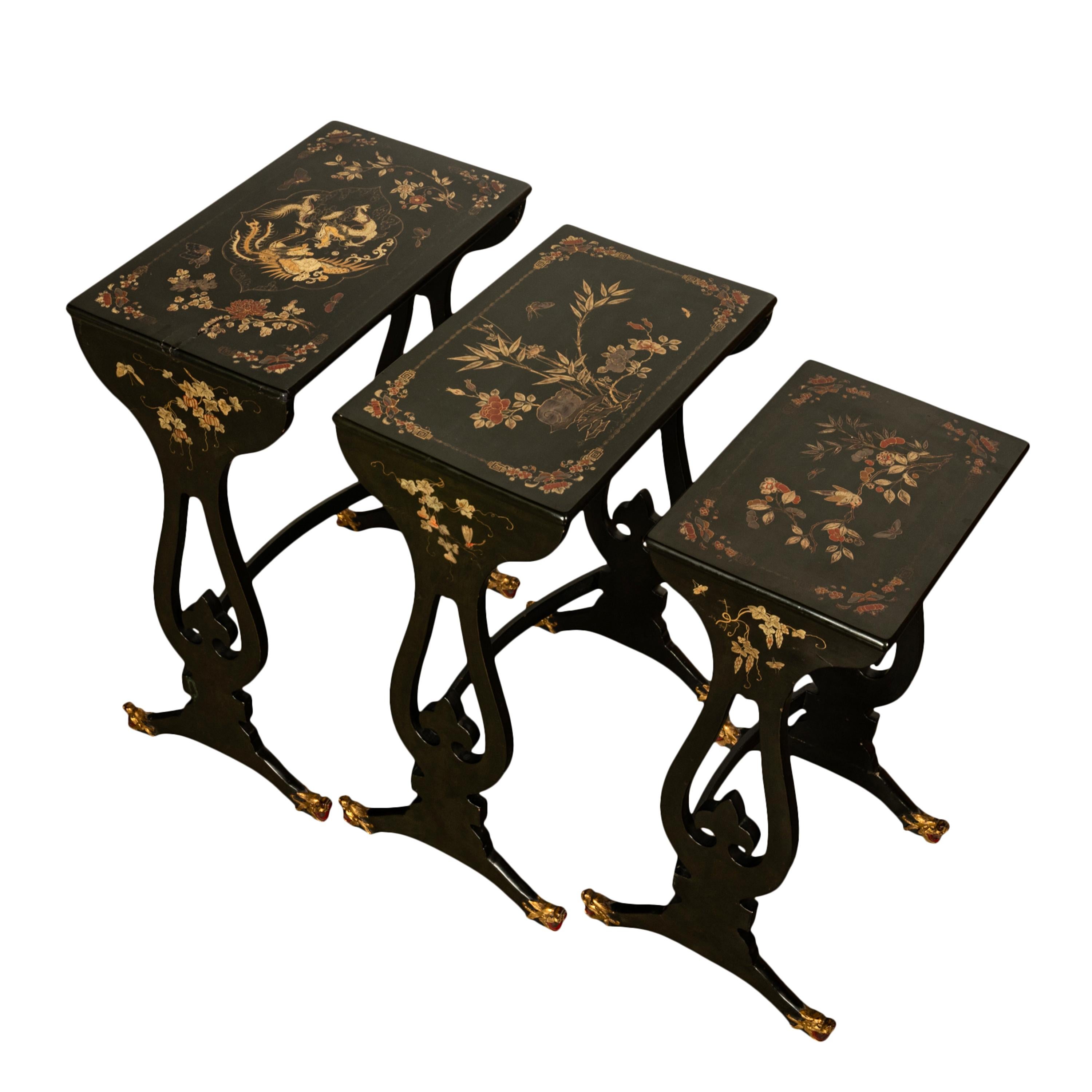 Un bel ensemble de trois tables d'exportation chinoises japannées et dorées, vers 1890.
Les tables sont japannées en laque noire et décorées à la main de motifs dorés. La table de tête est peinte d'un cartouche central avec un dragon et un phéonix,
