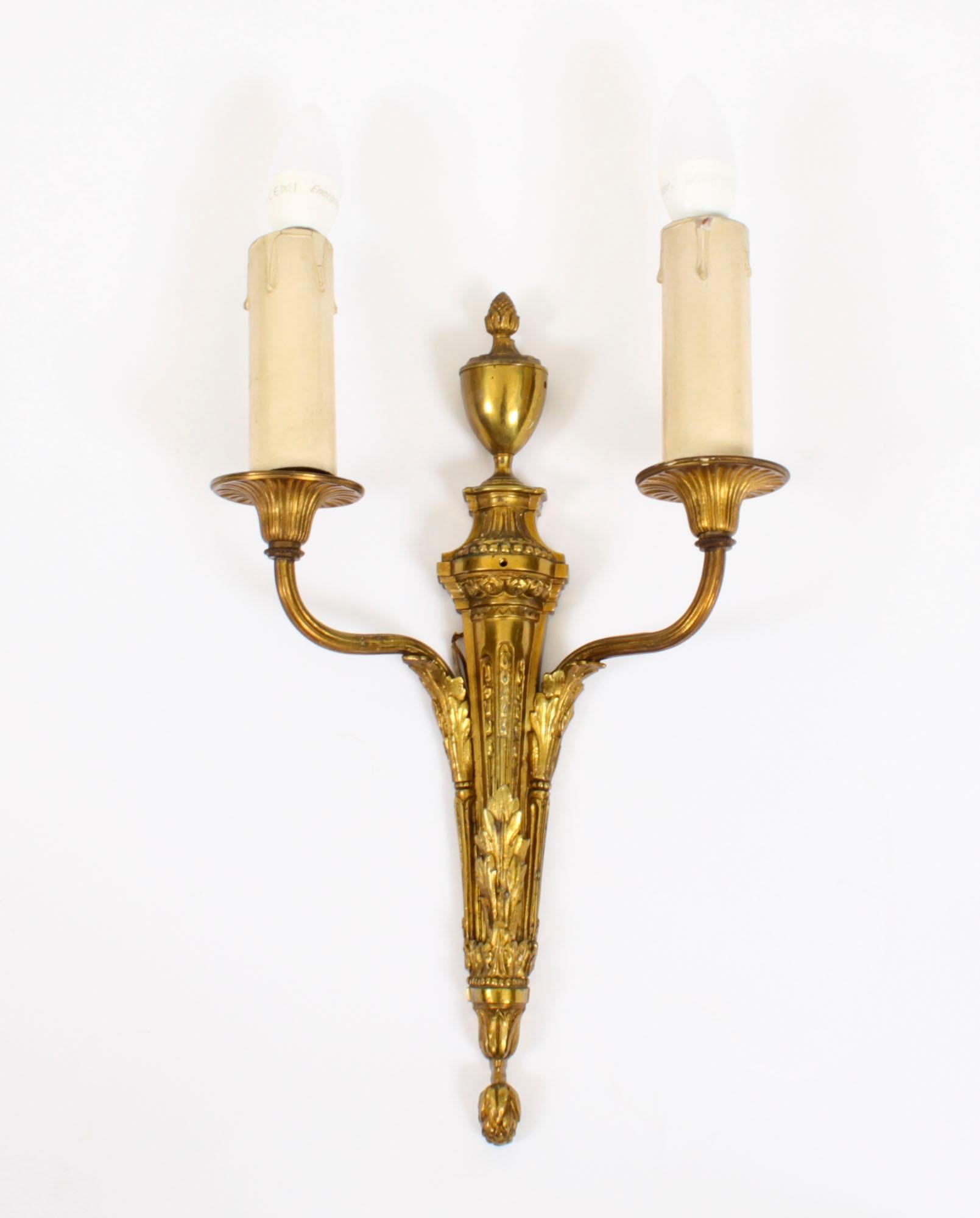This is a very fine set of four good sized Adam revival ormolu twin branch wall lights dating from the mid 19th Century.
 
The lights feature classical Regency elements with anthemion and classical flaming urn, with flame and scrolling drapery cast
