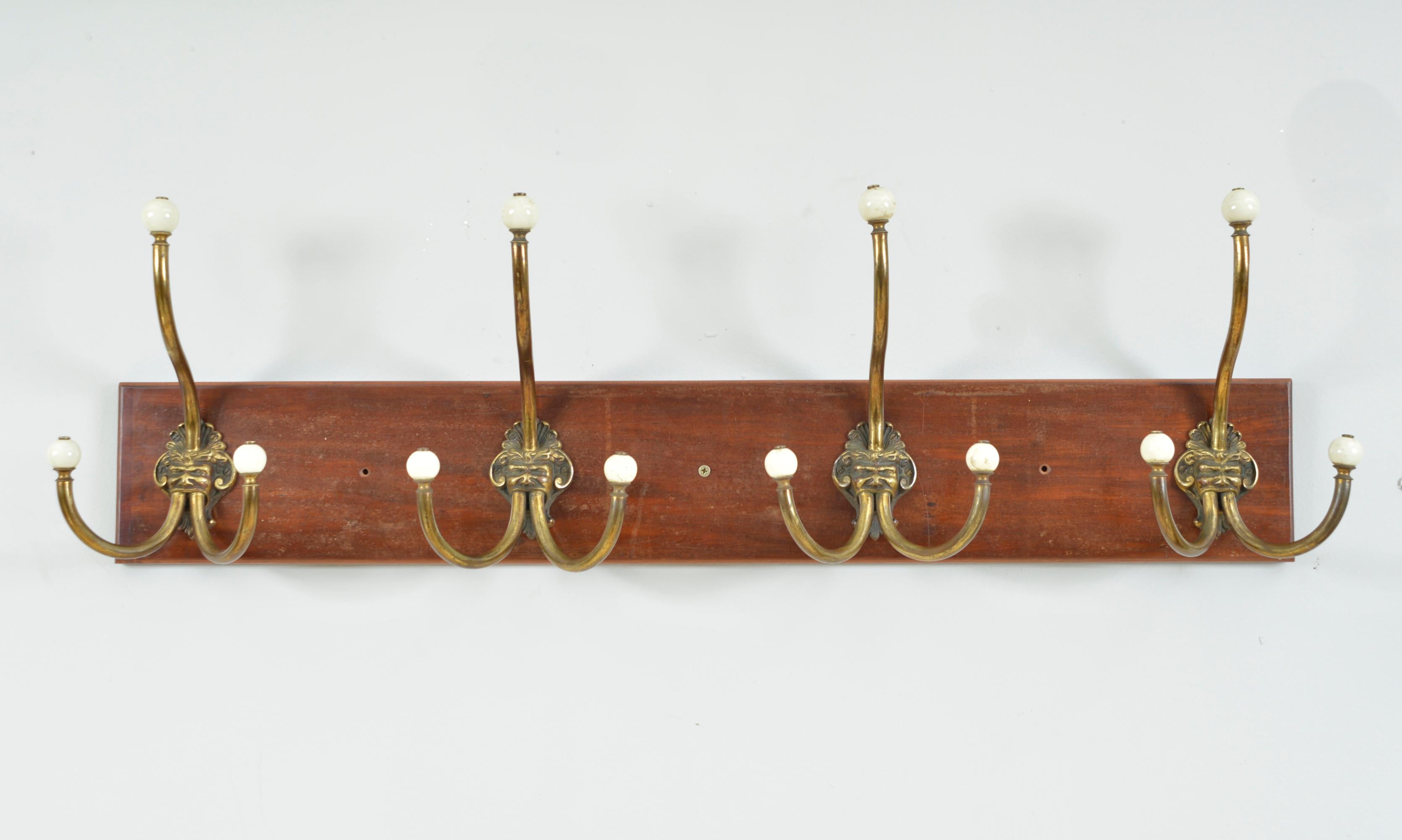 A rare set of four large antique brass and ceramic hat and coat hooks depicting a mythical “Green Man” or Satyr-like character, each impressed with “DEP Muster” to the back and mounted on a wooden plinth. Each hook has three brass branches, still
