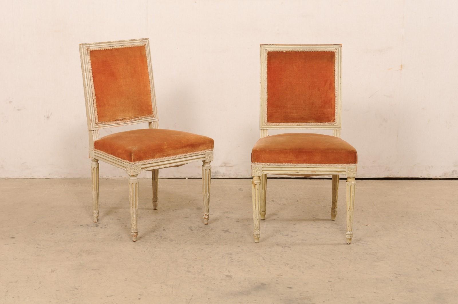 A French set of 10 Louis XVI style, square-back side chairs from the early 20th century. This antique set of chairs from France have been carved in the typical manner of the Louis XVI period, with the rosettes adorning their knees, and presented