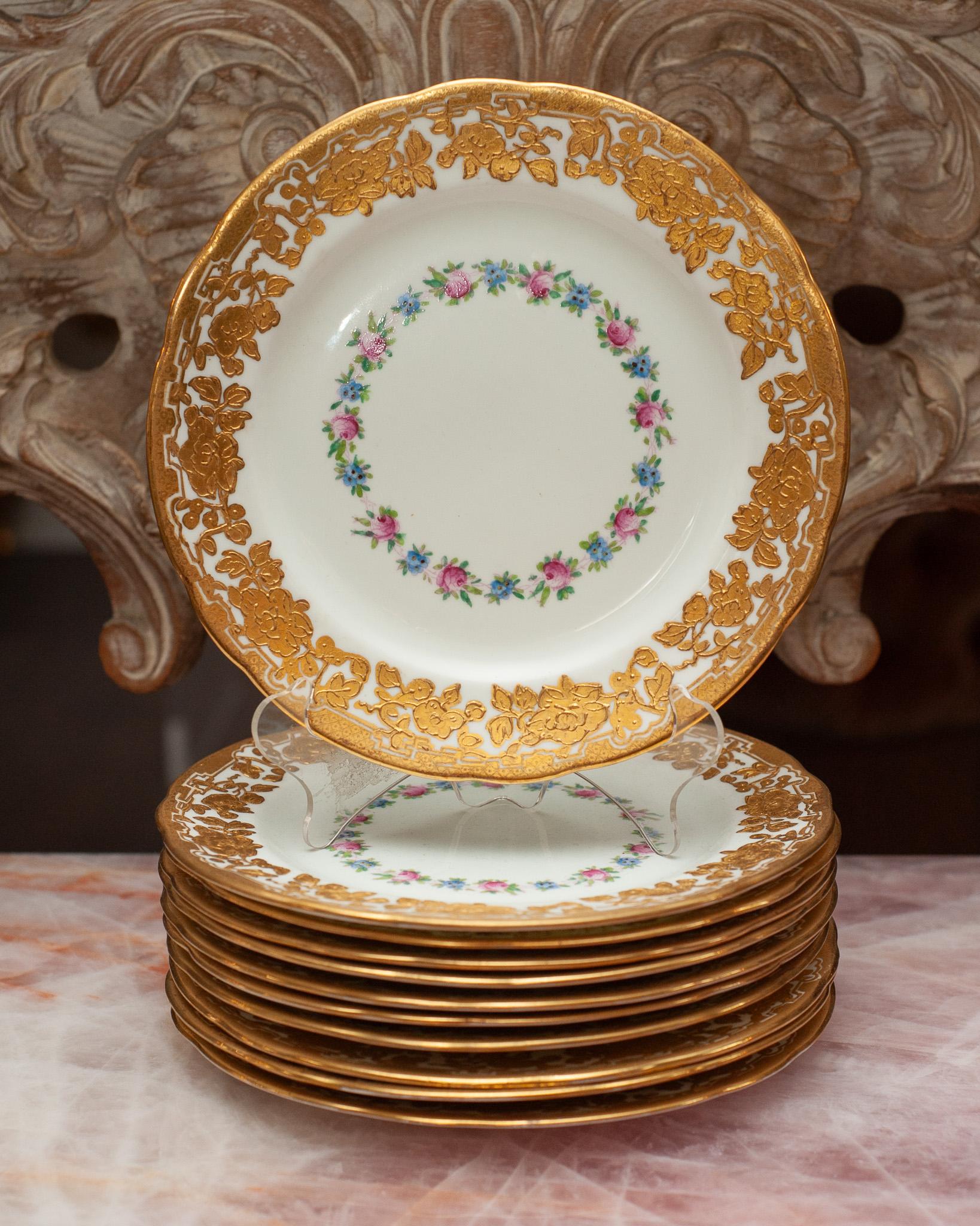 An antique set of 11 Ovington Brothers dessert plates made by Hammersley & Co, England. Beautifully gilded gold pattern with floral design.