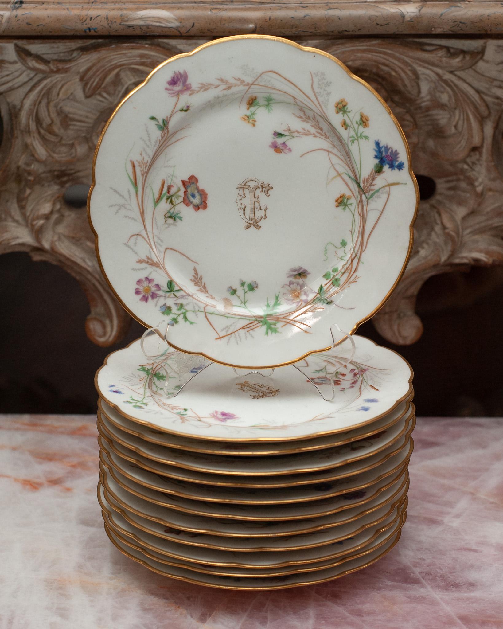 An antique set of 12 dessert plates by H. Beziat, France. Beautifully gilded gold scalloped edges, with floral design and CF initials.