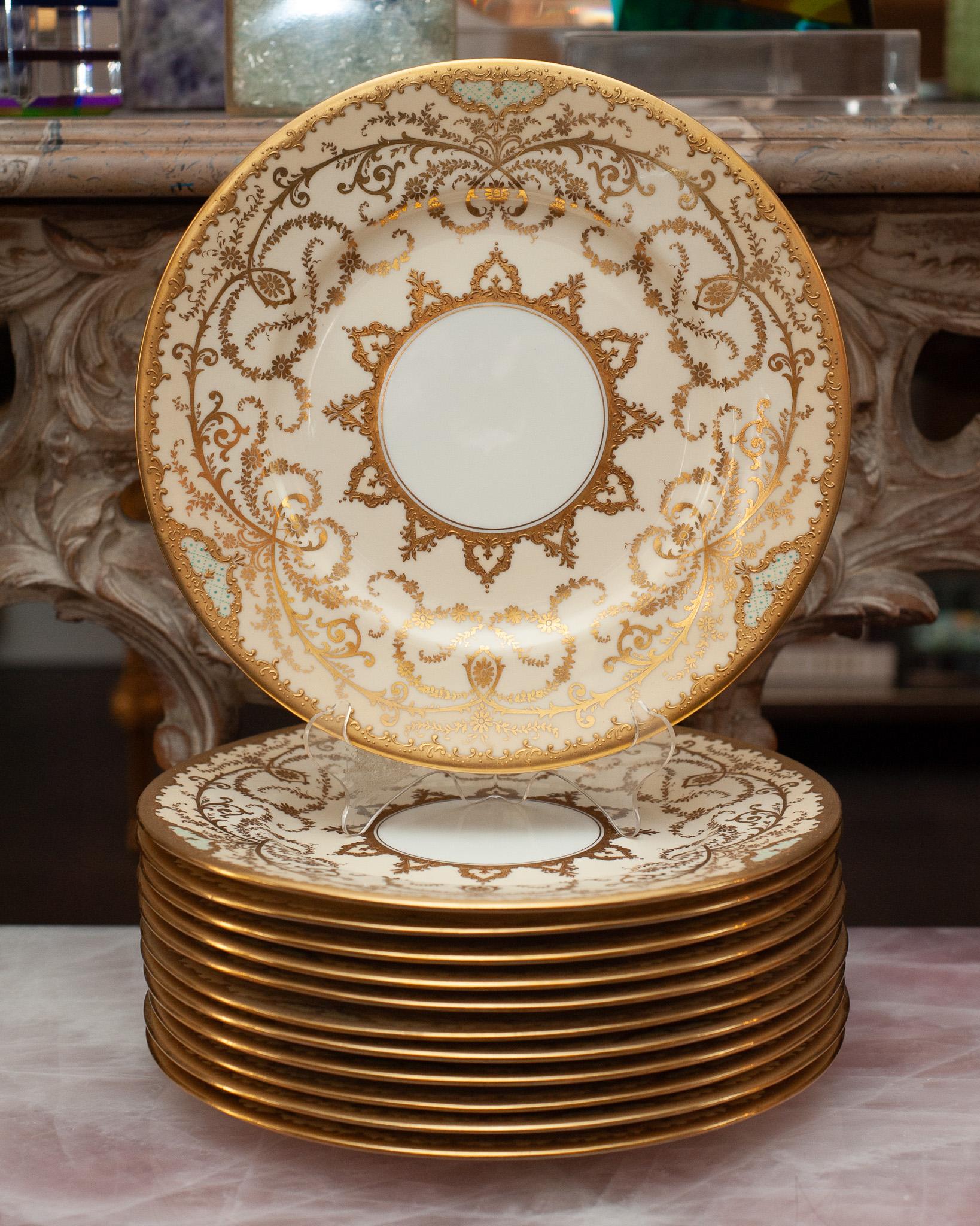 A beautiful set of 12 antique Coalport gold and cream dishes made for Ellis Brothers, Toronto. An ornate and impressive dinner plate set to uplift any table. 