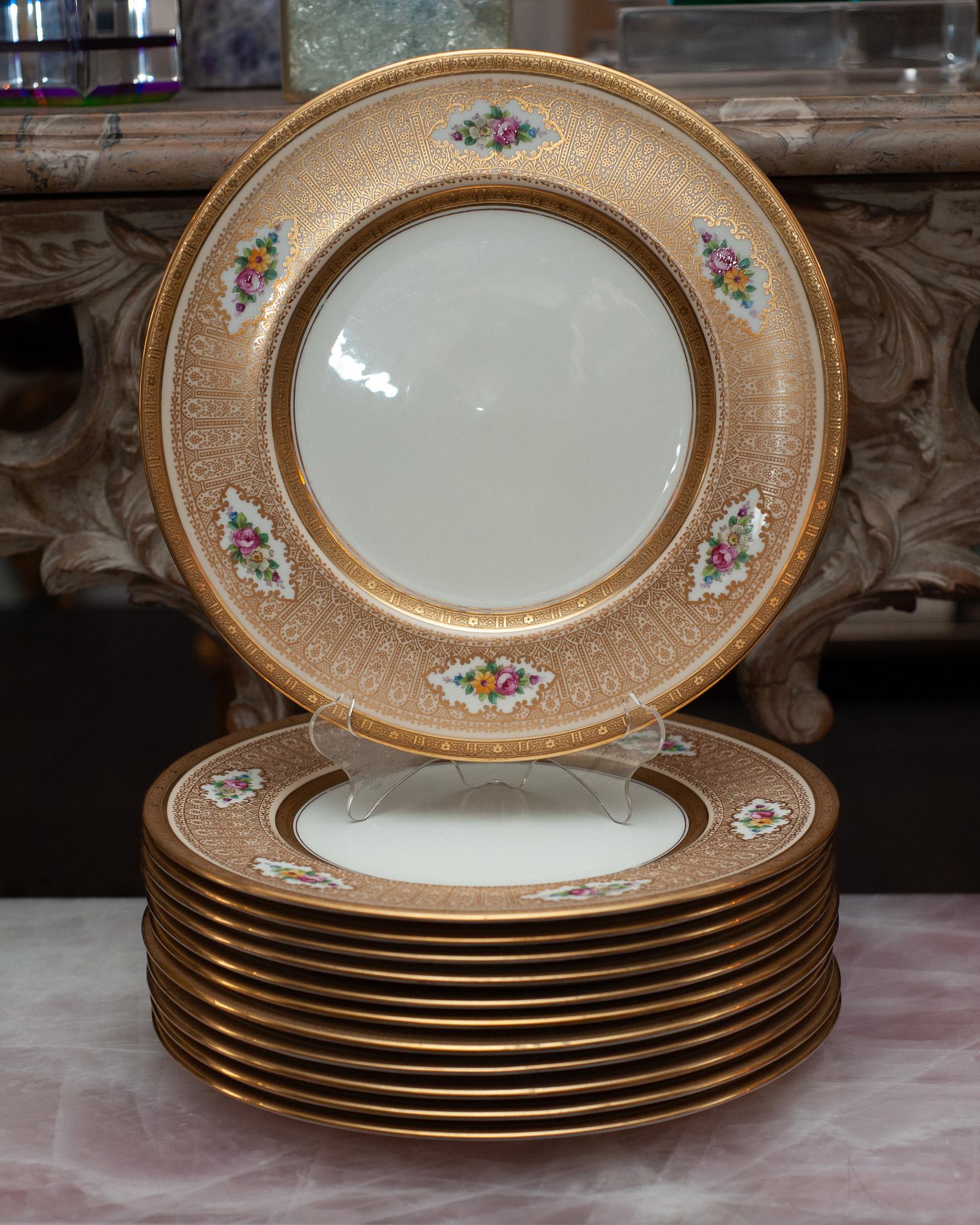 A stunning set of 12 antique gold and floral Cauldon dinner plates made for Cowell & Hubbard Co, Ohio. Elaborately gilded with a touch of floral motifs, these elegant and timeless plates will dress up any table and add richness to contemporary