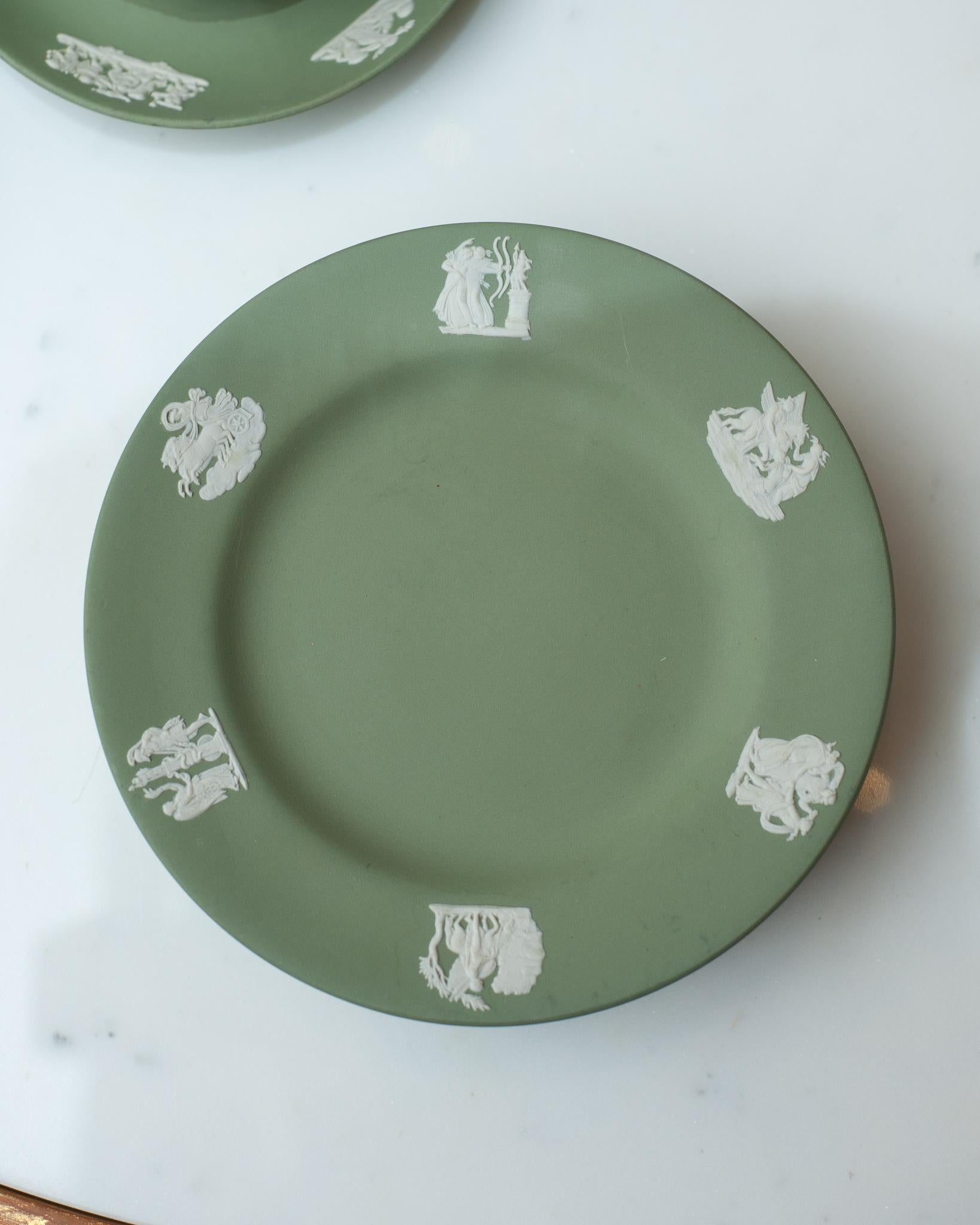 A stunning antique set of 12 Wedgwood sage green jasperware dessert plates with white overlay.