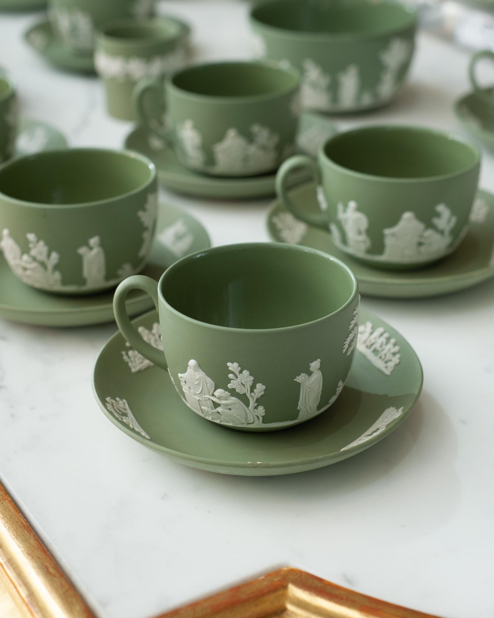 A stunning antique set of 12 Wedgwood Sage Green Jasperware teacups and saucers with white overlay.