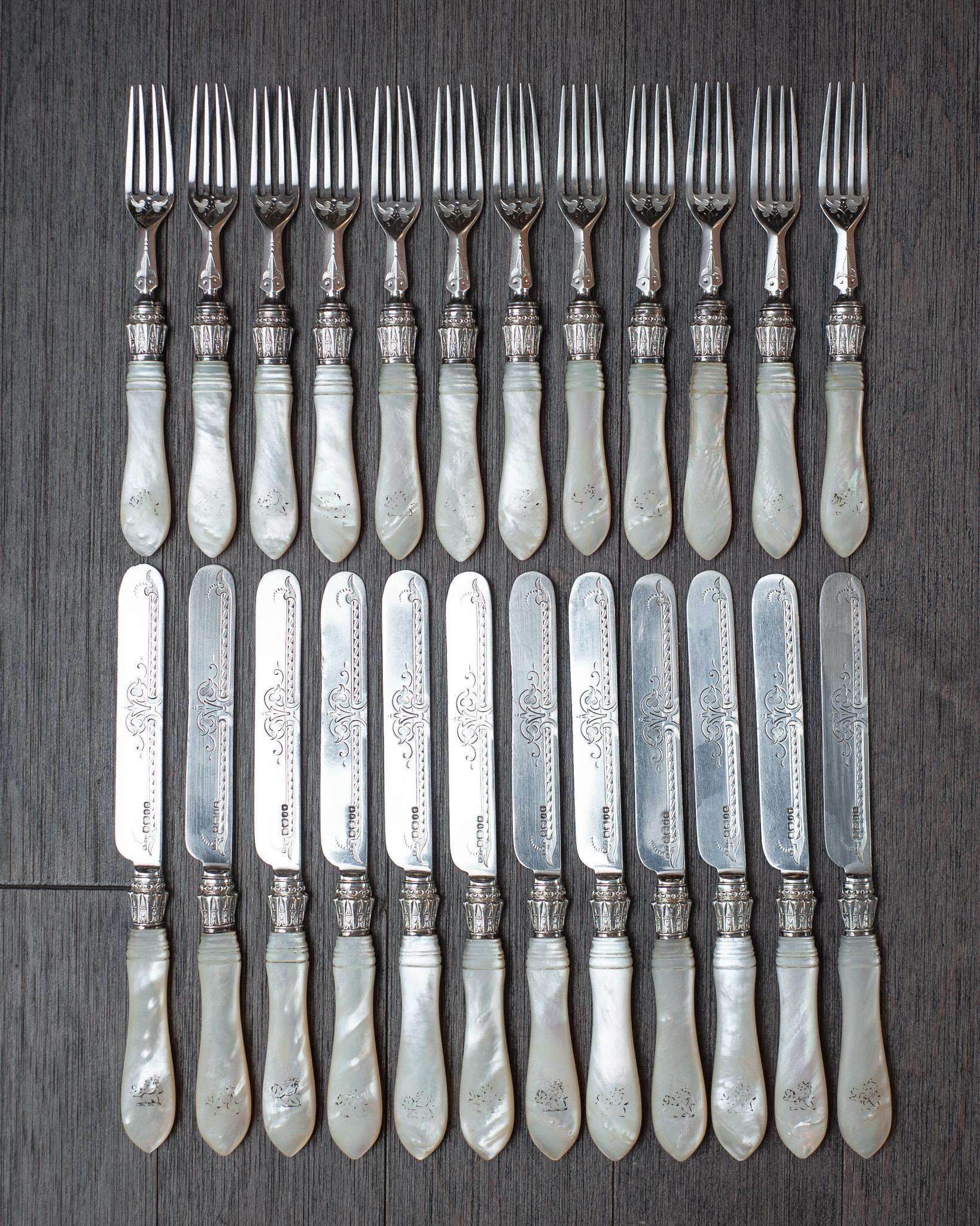 Un bellissimo set di 24 forchette e coltelli da dessert Sheffield con lame/linee in argento sterling incise e manici in madreperla. Ogni pezzo è marchiato come argento sterling e reca i marchi dei produttori: J. & J.B. (Walker & Hall,