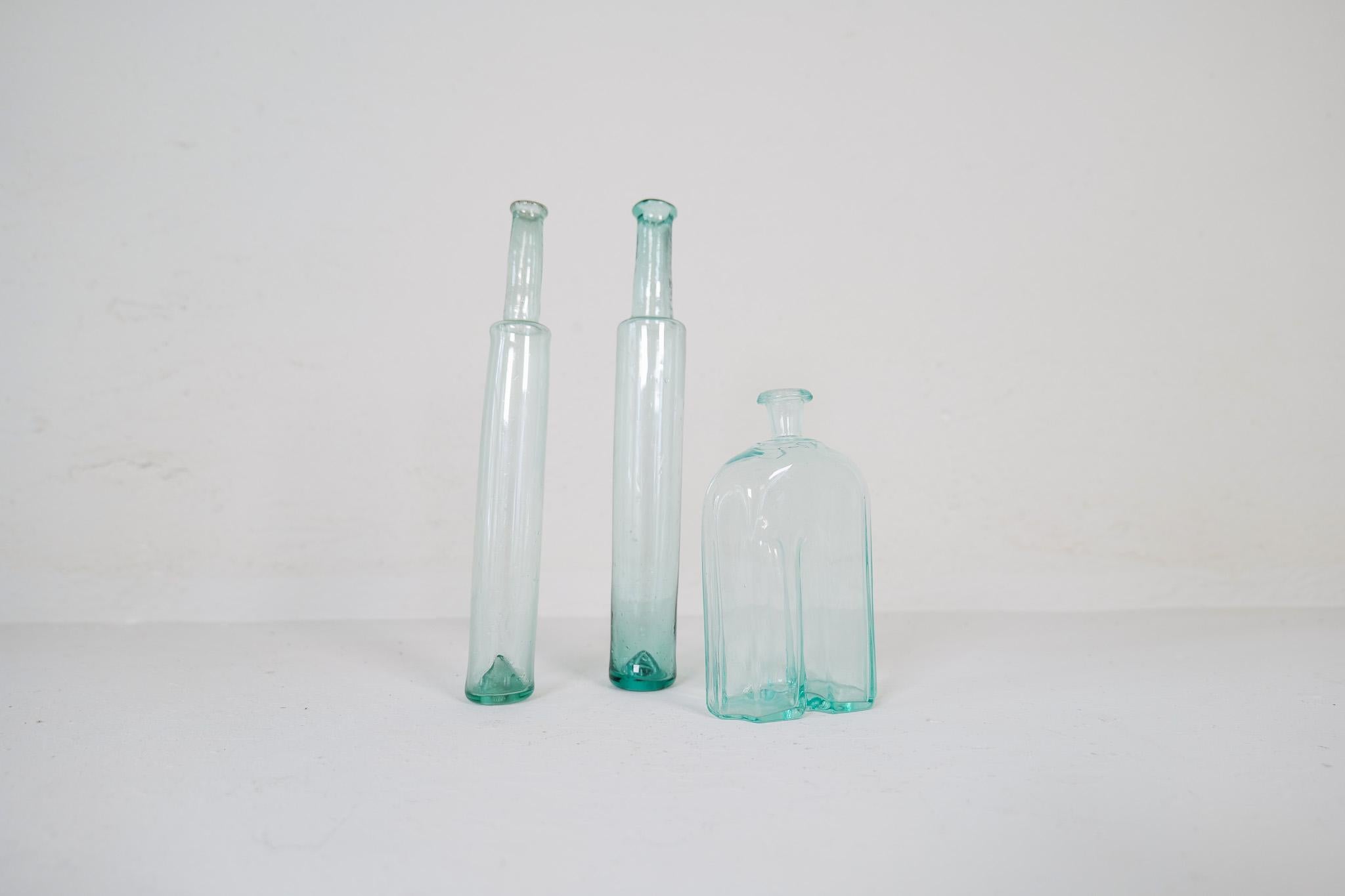 Cet ensemble de 3 bouteilles très décoratives a été fabriqué à la main en Suède au cours des années 1800. Les pièces donnent un aspect artistique lorsqu'elles sont assemblées. 

Vintage By, elles ne sont pas faites avec un fond droit et doivent être
