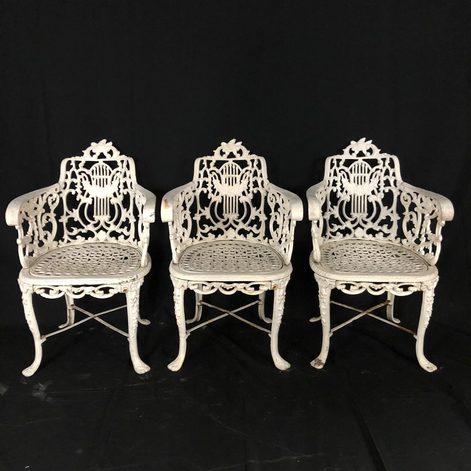 A beautiful set of 3 mid-19th century cast iron neoclassical or Greek Revival garden arm chairs attributed to the Robert Wood Foundry. The foundry was in Philadelphia Pennsylvania and created cast iron sculptures and decorations. Original design