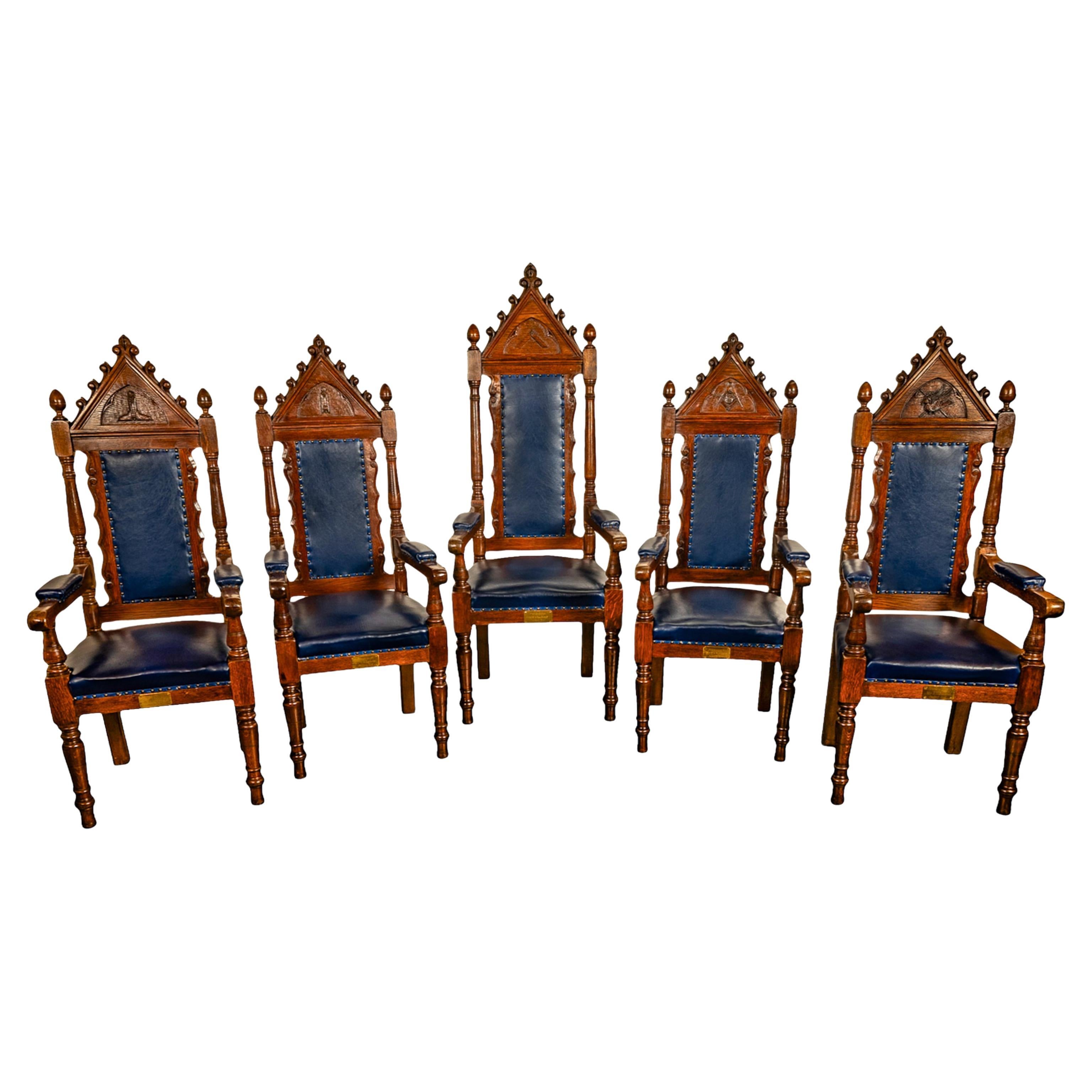 A fine set of five antique Gothic Revival oak & leather, Irish Masonic throne chairs, circa 1900.
Each chair having a pointed architectural pediment with scrolled devices and a scrolled finial to the top, each chair has a carved gothic tracery arch