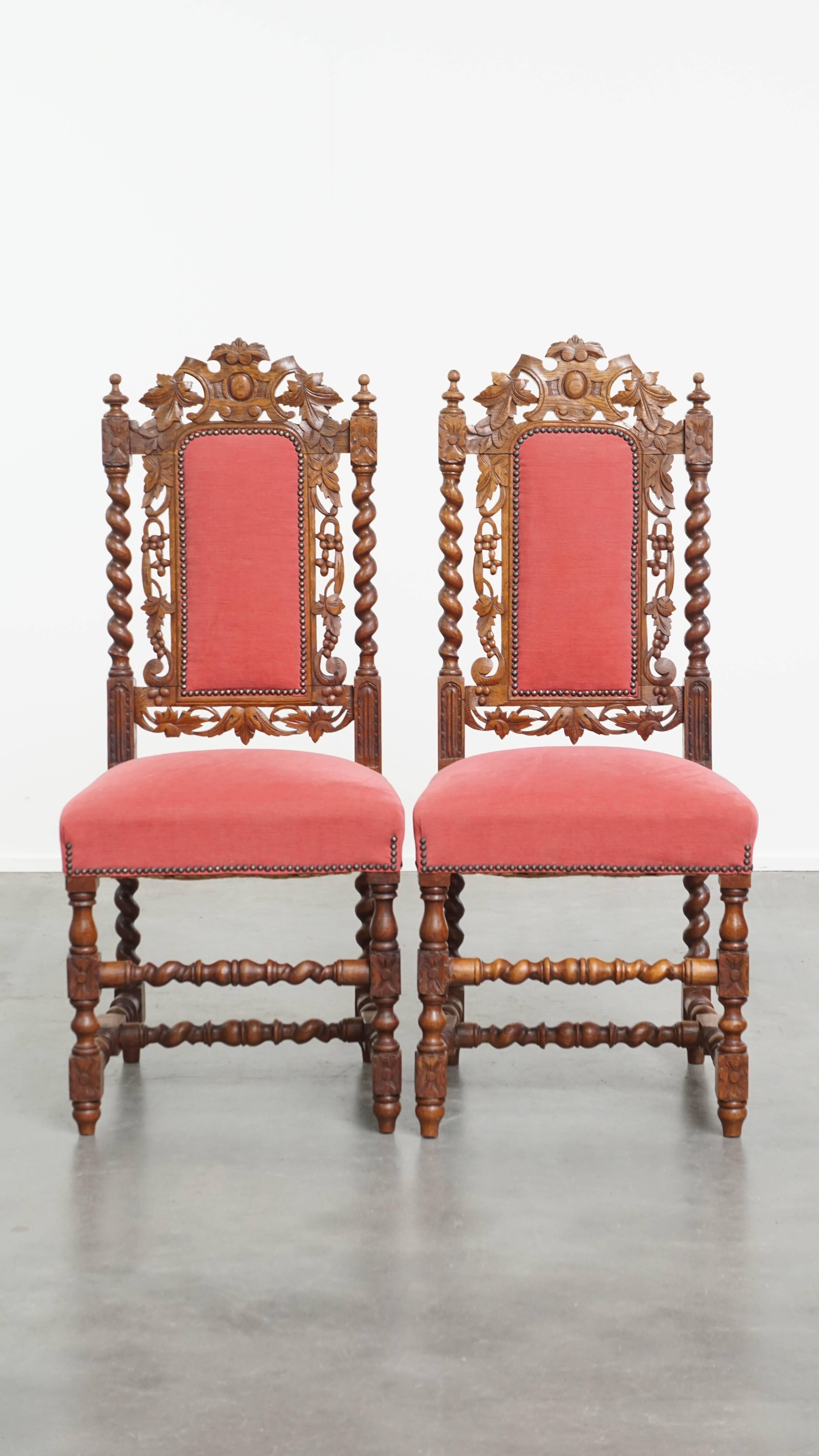 Offered here is this charming antique set of 6 Dutch dining chairs, featuring elegant woodcarving and red fabric upholstery with high backrests. These delightful chairs have a refined, graceful appearance thanks to their detailed carvings, and their
