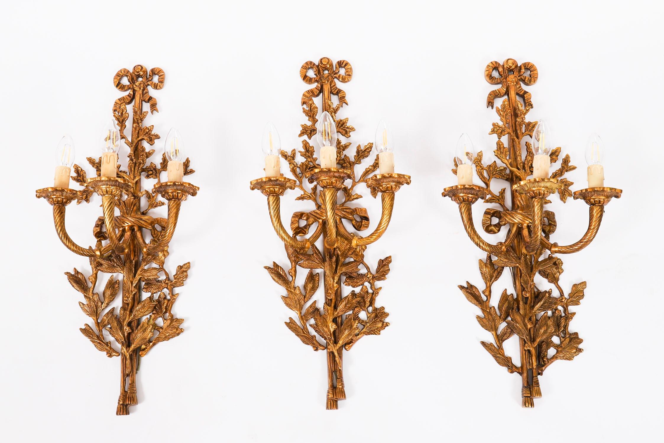 Un ensemble de six appliques anciennes de style Louis revival en bronze doré à trois branches, datant d'environ 1920.

Elles comportent chacune trois bras tordus en spirale sur des plaques arrière décorées de feuilles de chêne avec de grandes