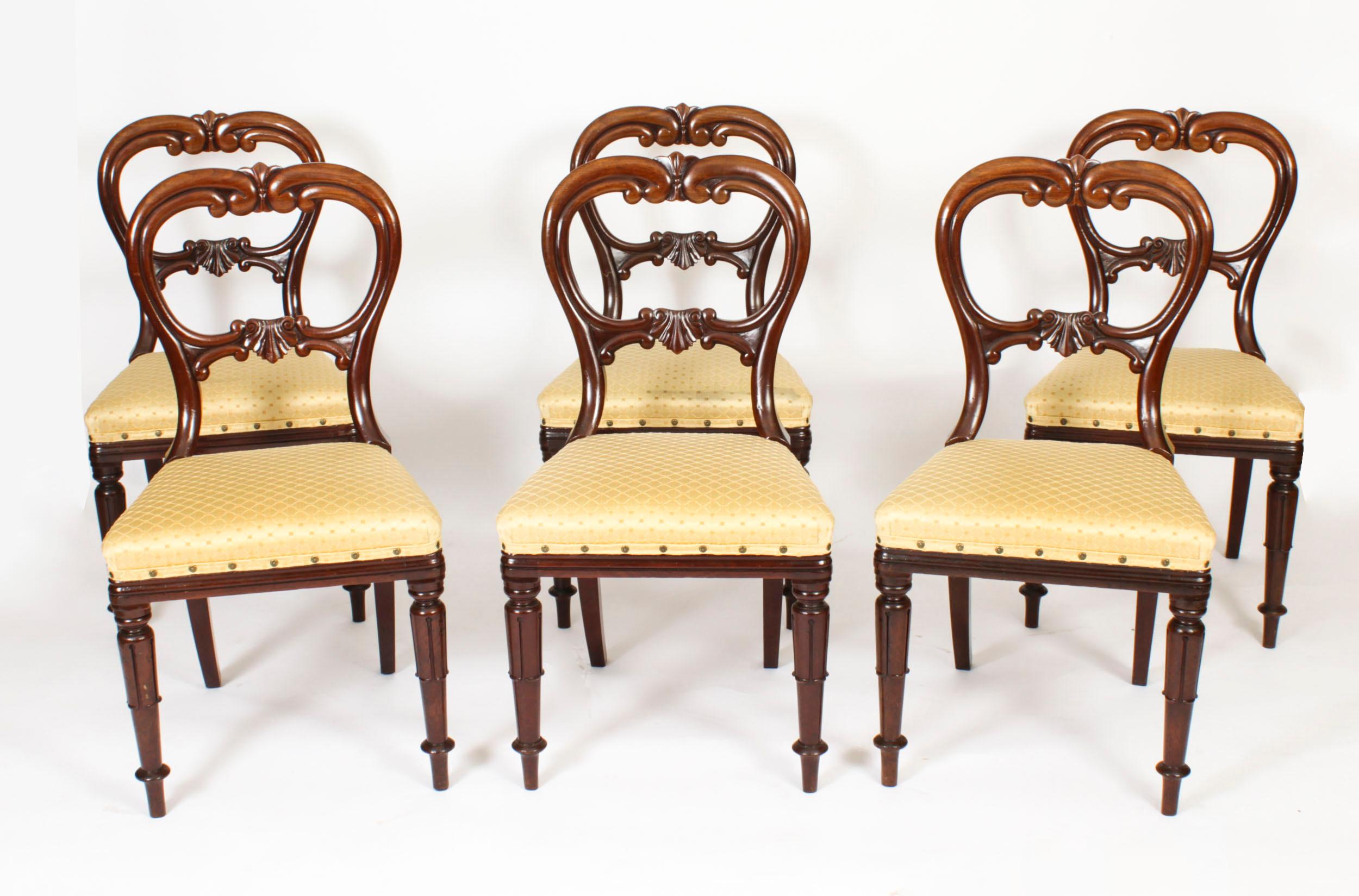 This is a beautiful set of six English antique Wiliam IV flame mahogany dining chairs, circa 1830 in date.

They have striking carved top and mid rails that feature decrative C scrolls and anthemion. The upholstered gold patterned silk over stuffed