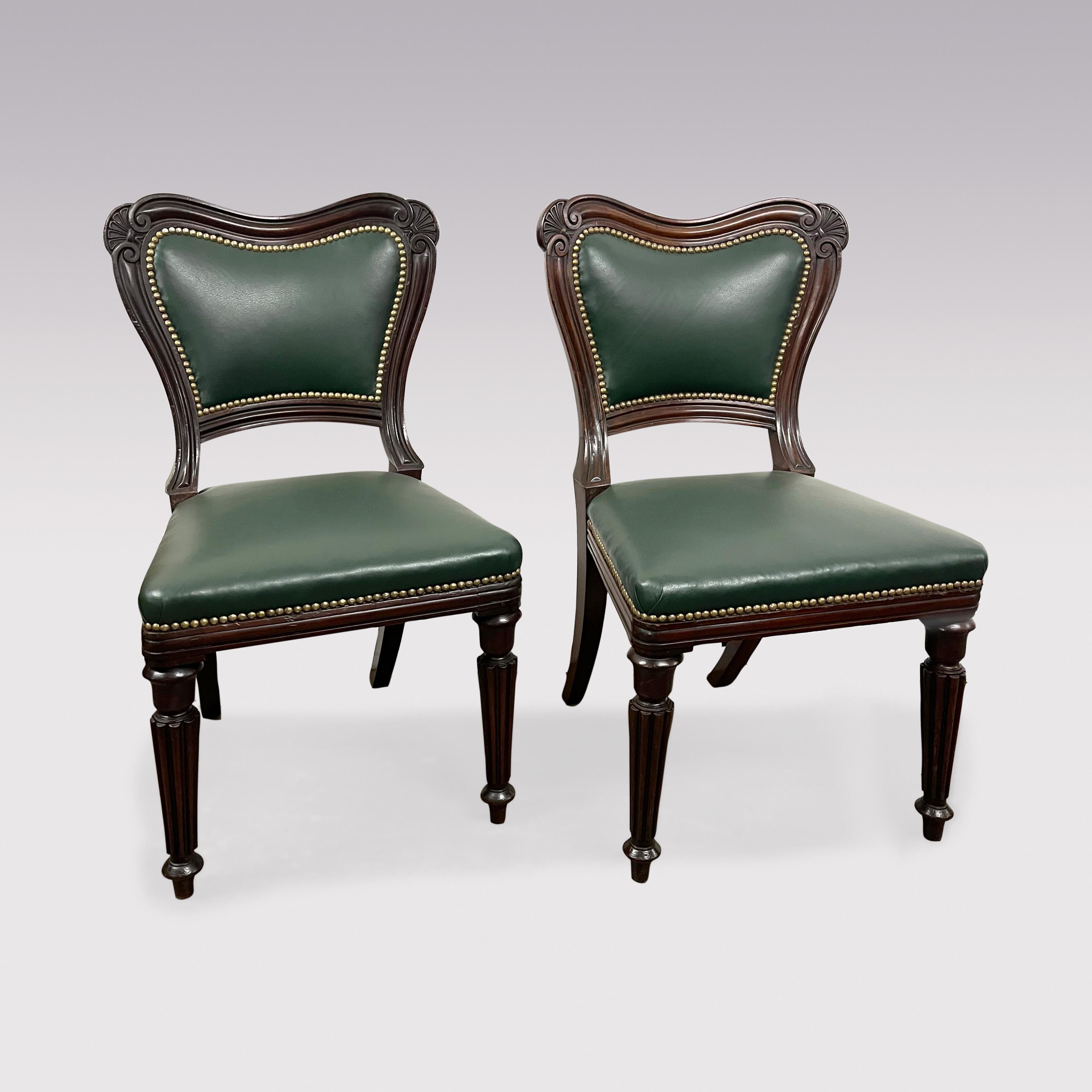 Un raffinato set di 8 sedie da pranzo a un braccio e a due bracci nello stile di Greene & Greene di Lancaster, con schienali sagomati rivestiti in pelle verde con angoli intagliati a volute e a ventaglio, sopra sedili impagliati che terminano con