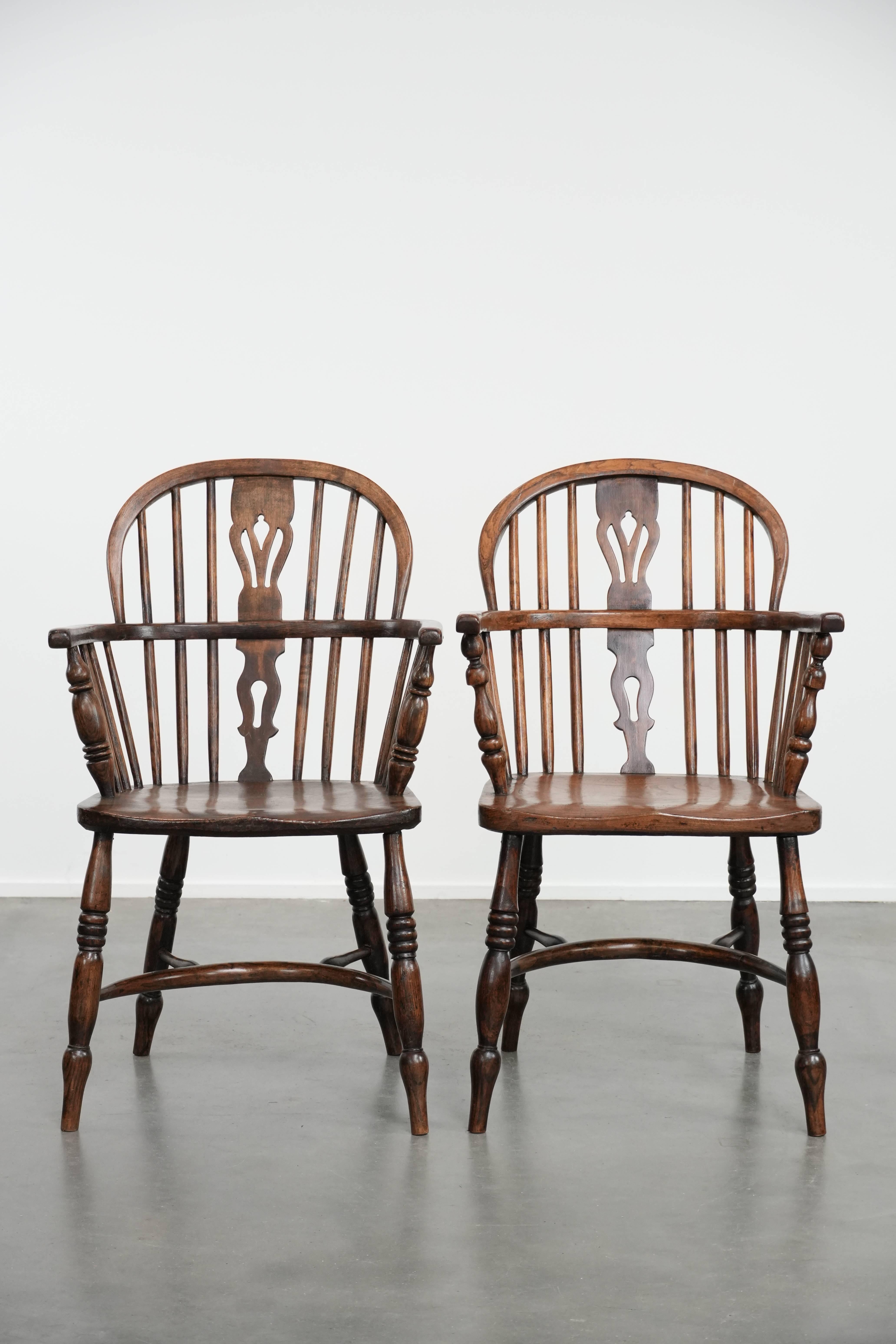Ce fantastique ensemble de huit chaises de salle à manger Windsor antiques à dossier bas a développé une merveilleuse patine au fil des ans. Ces chaises sont dotées d'un dossier en fuseau, d'une assise joliment façonnée et rayonnent de chaleur et de
