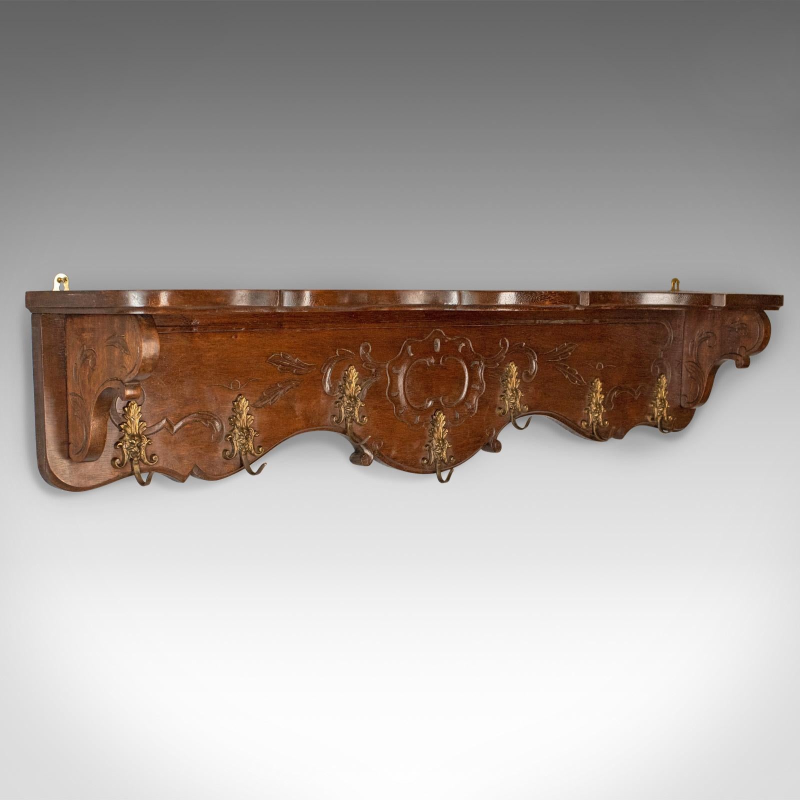This is an antique set of coat hooks, an English, Edwardian, wall mounted hall shelf in walnut dating to the early 20th century, circa 1910.

Broad, of serpentine form and useful proportions
In stout stocks of walnut displaying good colour
