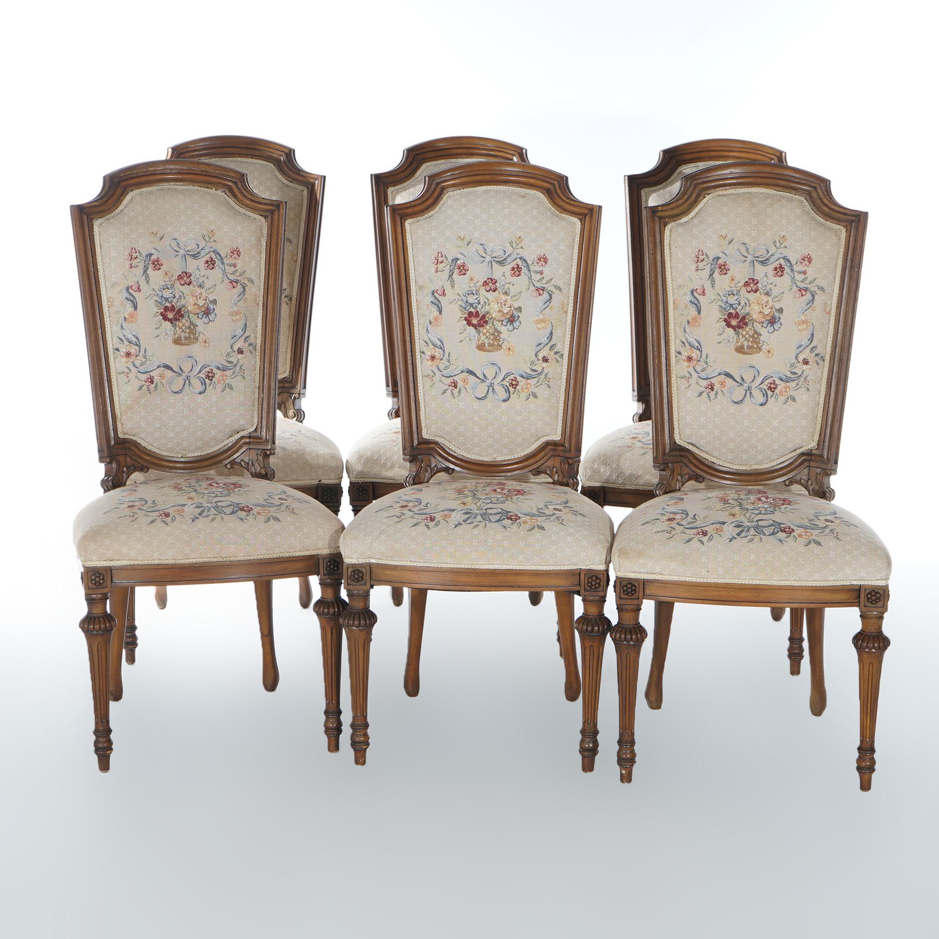 A set of eight antique French Louis XVI dining chairs offer walnut
frames with floral tapestry upholstery and raised on turned, tapered and reeded legs; master with scroll form and covered arms; includes single master with seven side chairs;