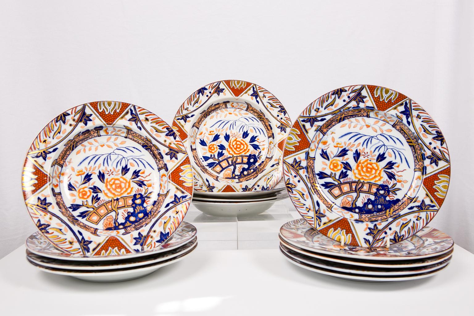We are pleased to offer this extensive set of English Imari dishes painted in iron red, deep blue, and gold showing a garden scene. Each dish is fully decorated in a pattern with large peonies and a flowering tree issuing from blue Taihu rocks. The