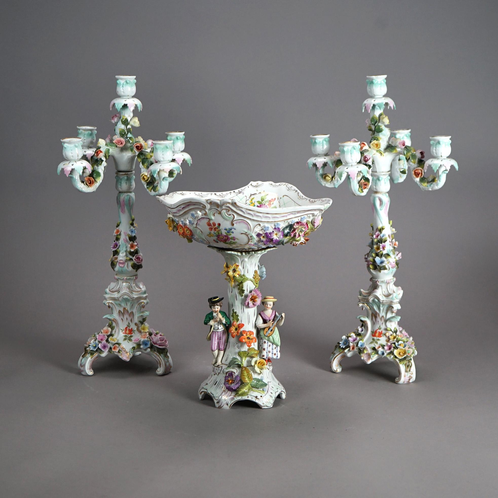 An antique garniture set offers Dresden porcelain construction with courting couple and applied floral elements; hand painted with gilt highlights; en verso blue maker mark as photographed; c1890

Measures - Compote 13.5