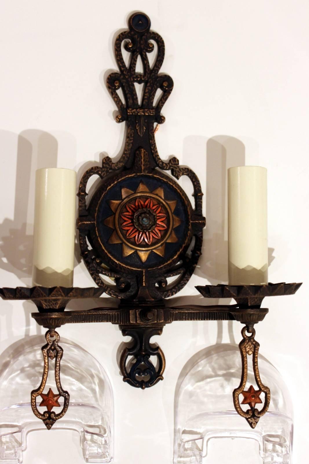 A set of four cast brass patinated and poly chromed two-light wall sconces. These have all the original details with brand new wiring. The sconces have individual on and off switches on each. These are original circa 1910 in great condition with new