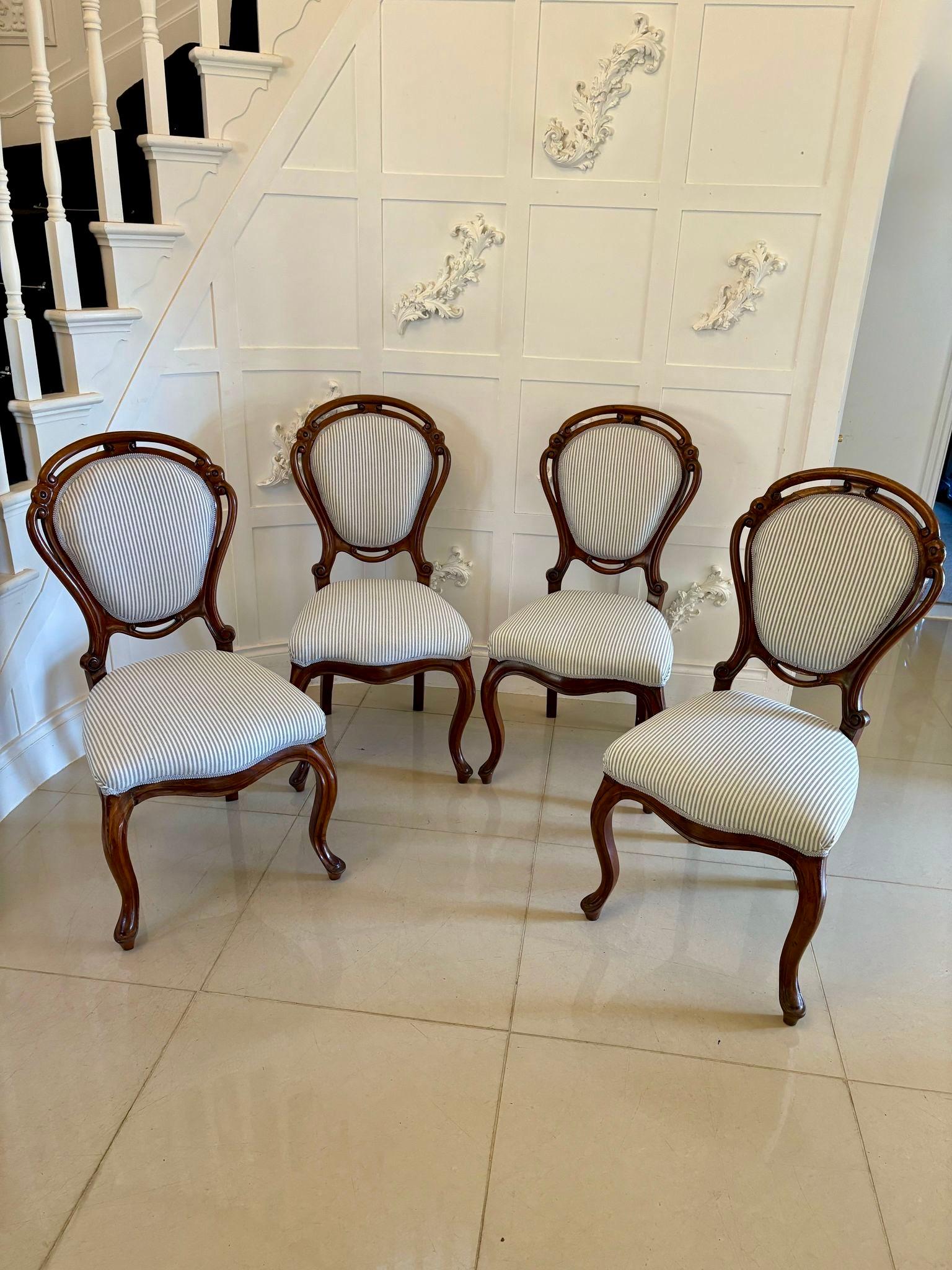 Antique set of four fine quality Victorian walnut balloon back dining chairs having a padded balloon back with carved and pierced tops, newly reupholstered backs and seats standing on shaped cabriole legs with scroll feet to the front and out swept