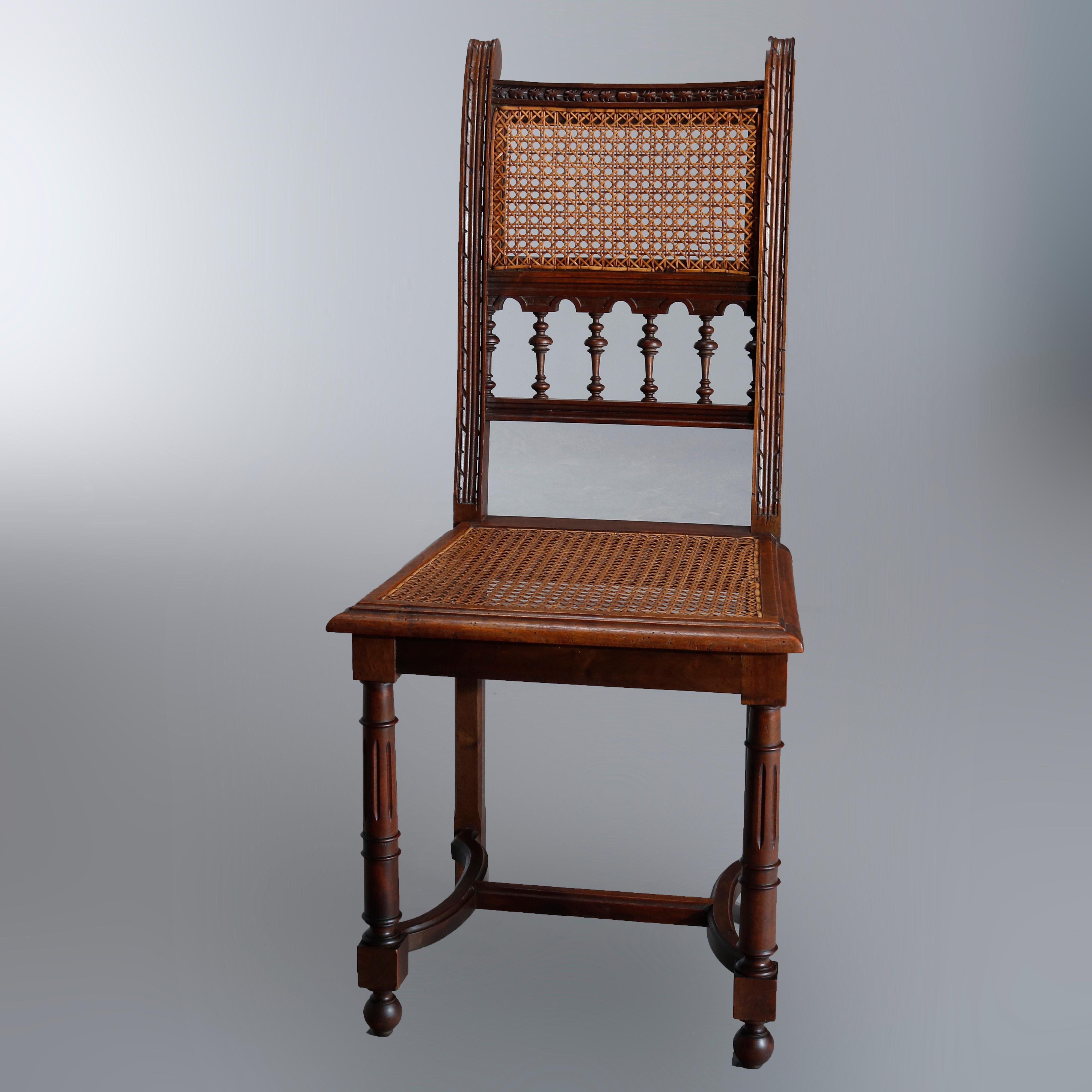 Set of four antique Italian walnut dining chairs having foliate carved crest rail over cane backs with spindle rail over cane seats raised on turned and reeded legs with bun feet and stylized H-stretcher base, circa 1900.

Measures: 37.5