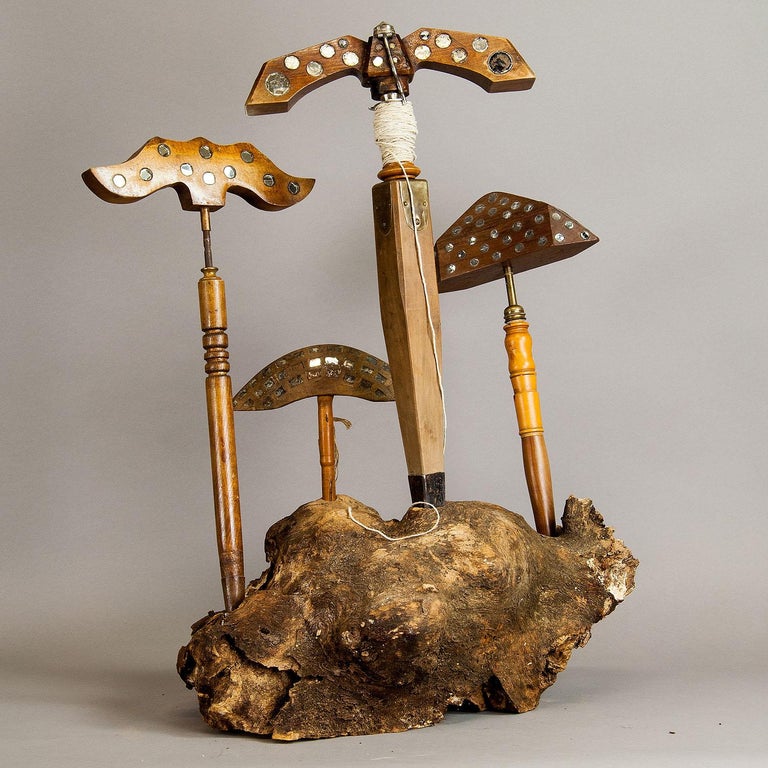 This is a set of four lark mirrors which have been used for fowling. Birds are frightened by turning the wooden piece on top of the tools. Displayed on a large piece of root wood.

Measures: Width 21.65