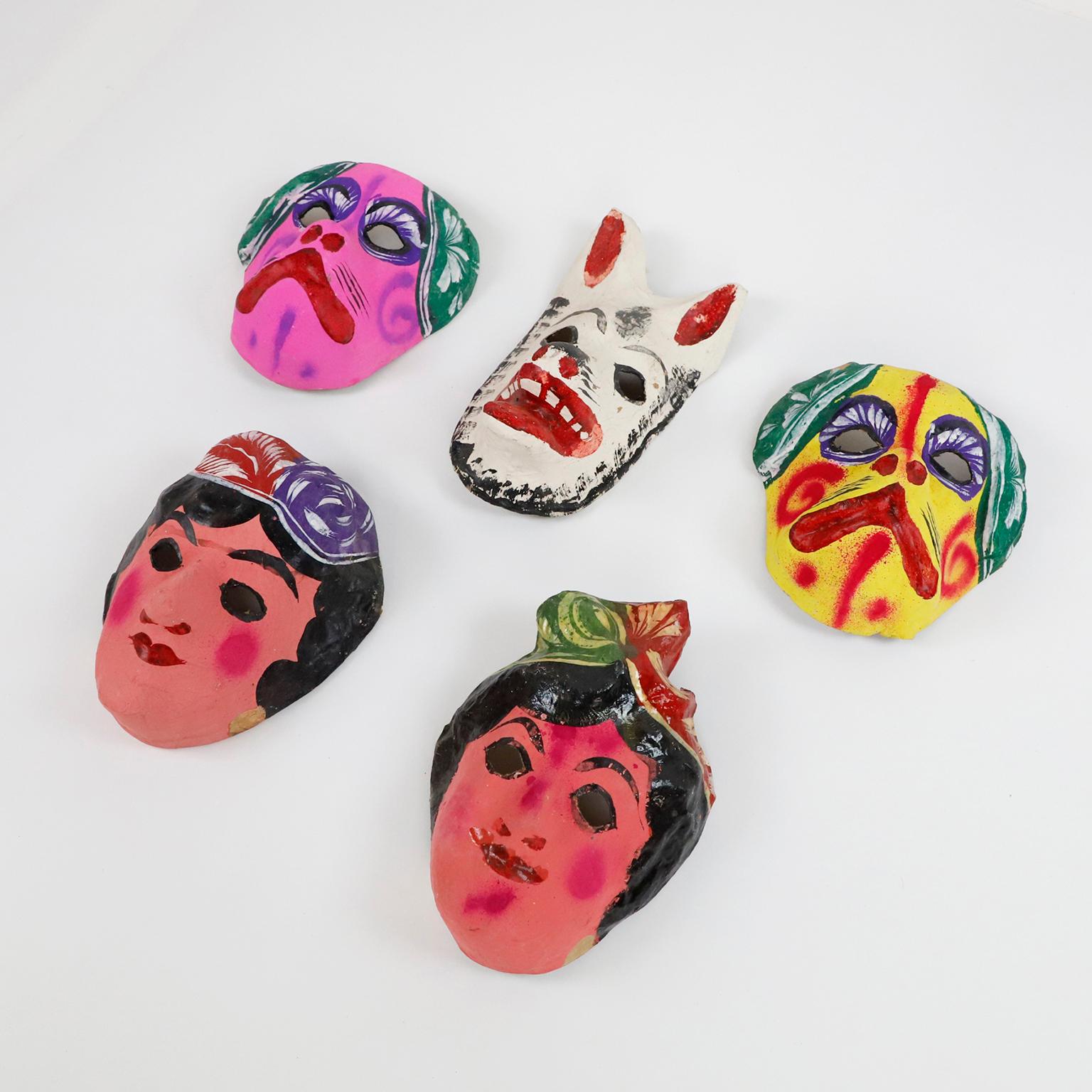 Circa 1960. Wir bieten dieses antike Set von 5 mexikanischen Pappmaché-Masken an, die zu 100% handgefertigt und mit Anilin (natürlichen Pigmenten) bemalt sind.