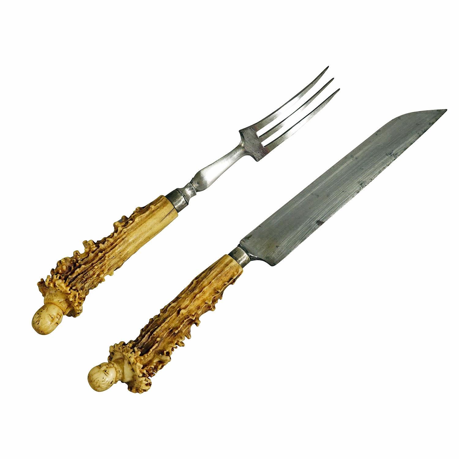Antikes rustikales Servierbesteck mit geschnitzten Griffen aus Horn 19.

Ein seltener antiker Satz von Messer und Gabel als Servierbesteck. Die Griffe sind aus Hirschhorn mit handgeschnitzten Köpfen viktorianischer Kinder an ihren Enden. Zinken und