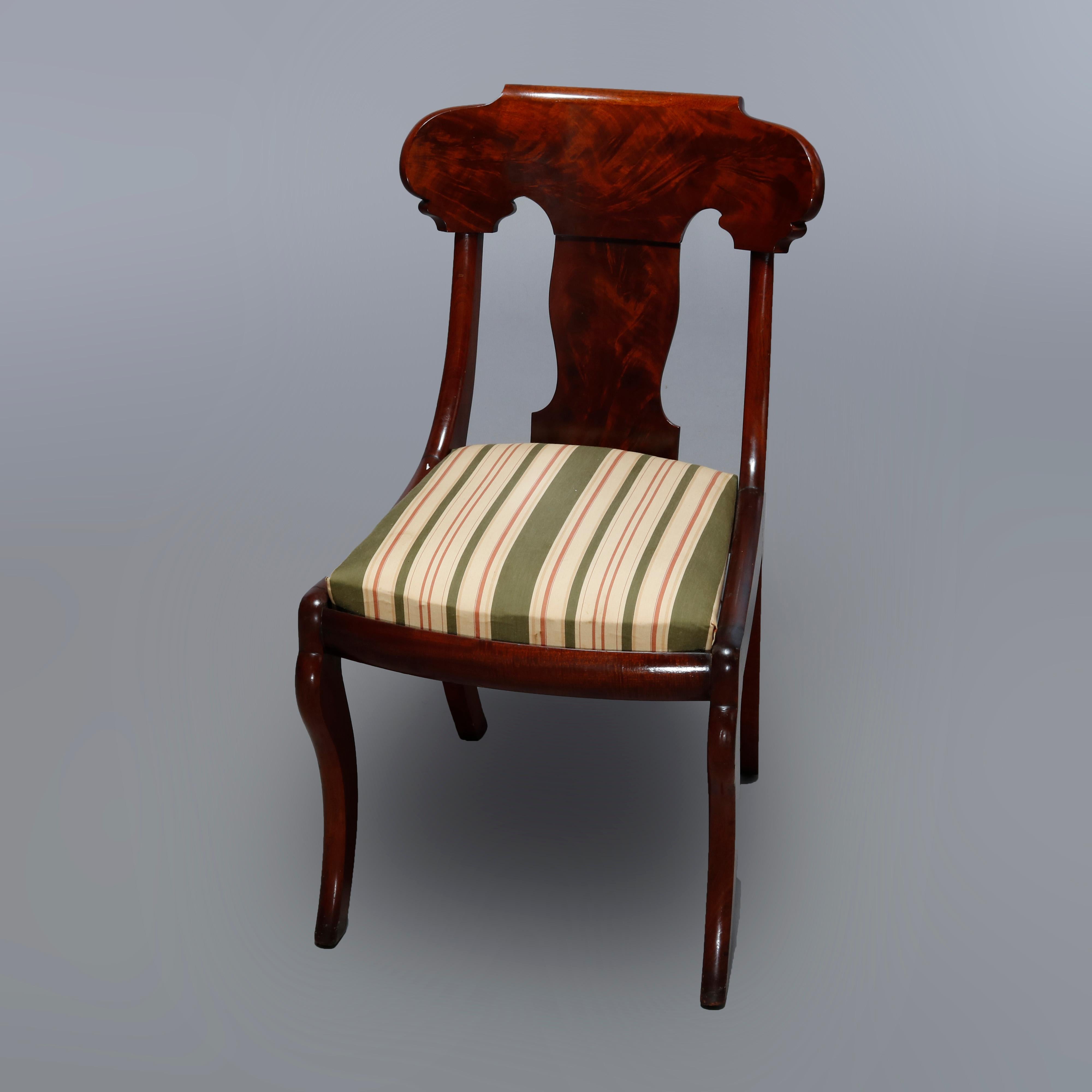 An antique set of six dining chairs offer flame mahogany construction in gondola form raised on saber legs, 19th century

Measures: 32.25