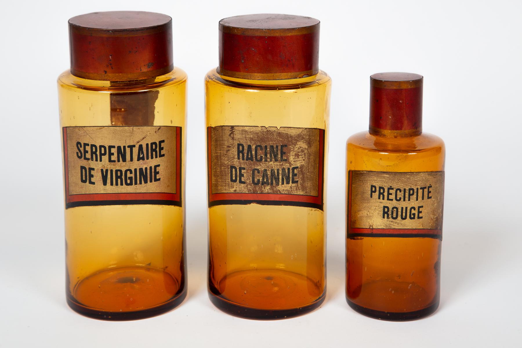 Antico set di tre vasi da farmacia in vetro, XIX secolo, Francia. Bellissimo vetro ambrato con etichette dipinte al contrario e coperchi in toleware rosso. Etichetta originale in carta sul retro della Serpentine De Virginie.