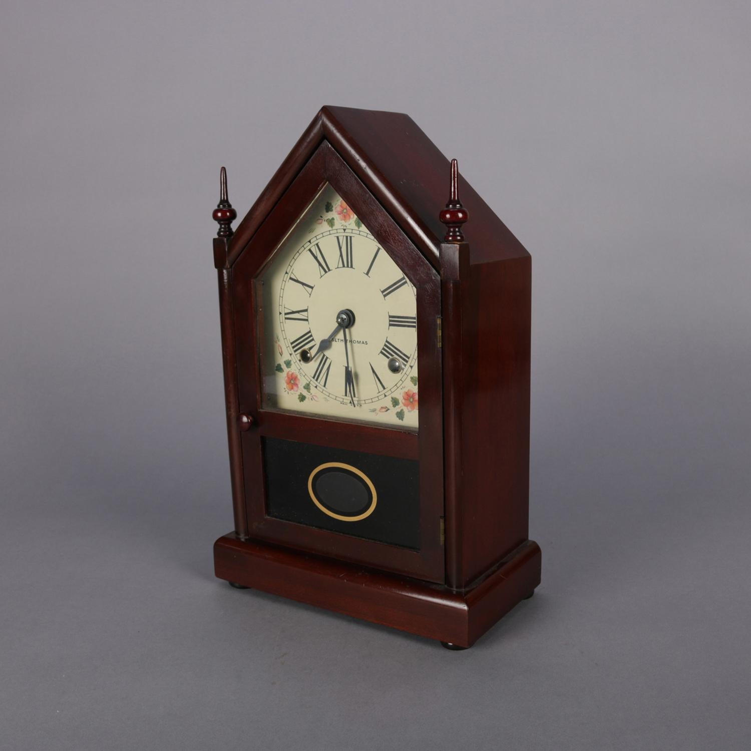 Antique steeple mantel clock by Seth Thomas features mahogany case, hand painted face with Roman numerals with intermittent floral spray and signed Seth Thomas, working and with key chiming on hour and half hour, 20th century

Measures: 14.75