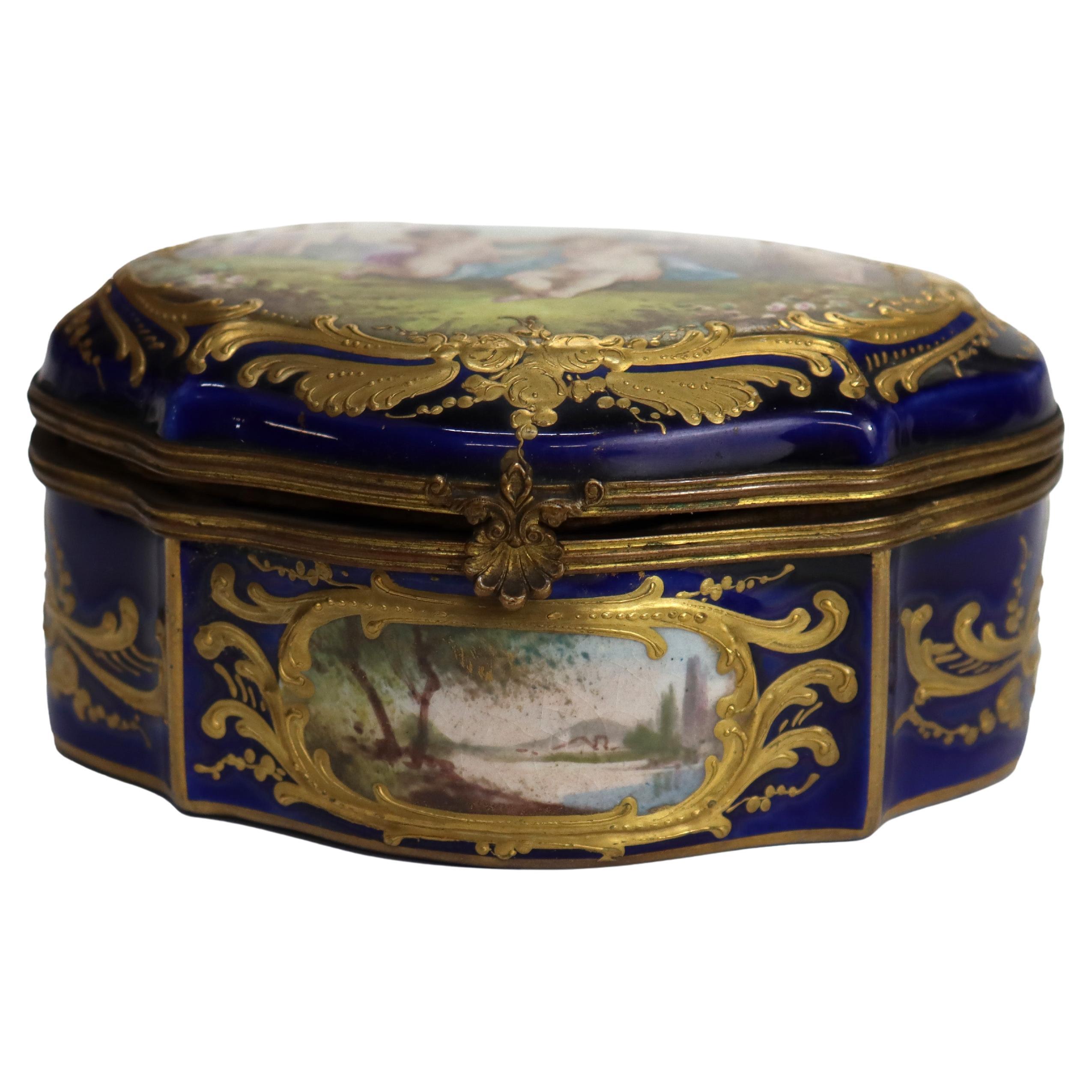 Pequeña cómoda antigua de porcelana dorada de Sevres y azul real con querubines, firmada, C1880.   
Medidas - 2