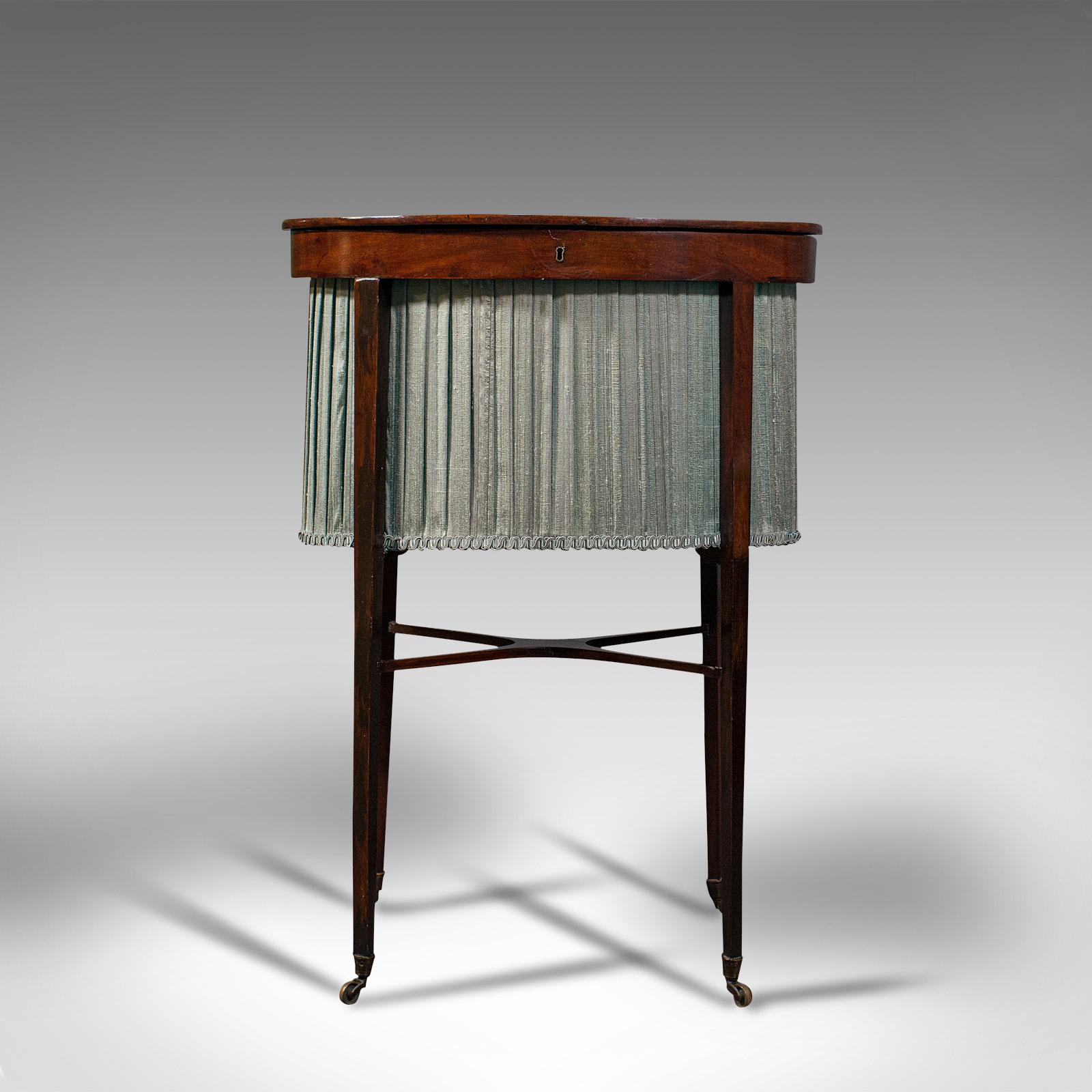 This is an antique sewing table. An English, mahogany and silk cotton ladies work table, dating to the Regency period, circa 1820.

Elegantly dressed sewing table from the Regency period
Displays a desirable aged patina and in good order
Select