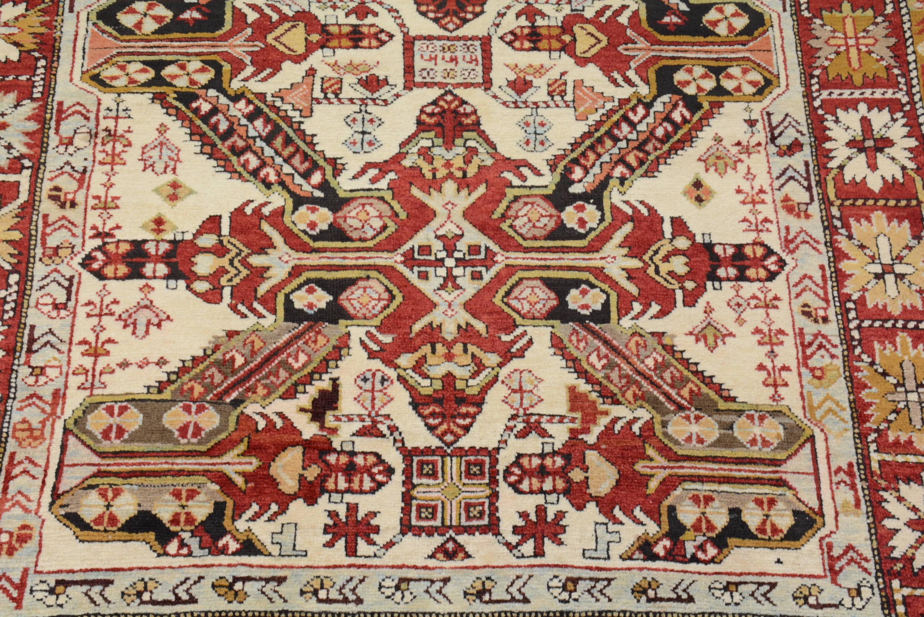 An antique Caucasian Seychour rug, dated 1333AH/1915AD. This rug has a bold pattern of two St. Andrew's Crosses on an ivory field within a madder border. In excellent, original condition, 5' 1