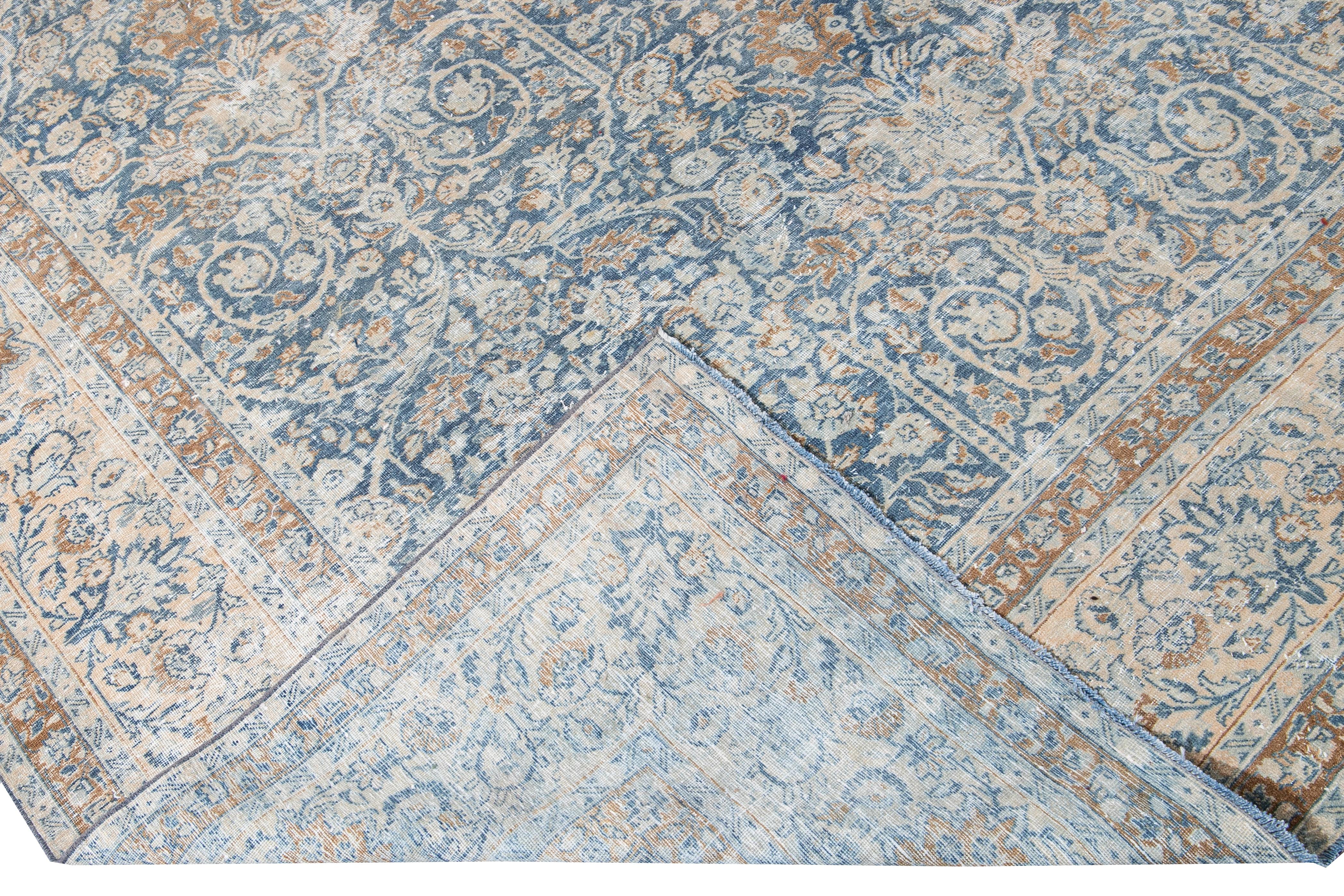 Schöner antiker, übergroßer, handgeknüpfter Wollteppich aus Täbris mit blauem Feld. Dieser Teppich hat eine pfirsichfarbene Umrandung und braune Akzente in einem wunderschönen floralen All-Over-Design im Shabby-Chic-Stil.

Dieser Teppich misst: