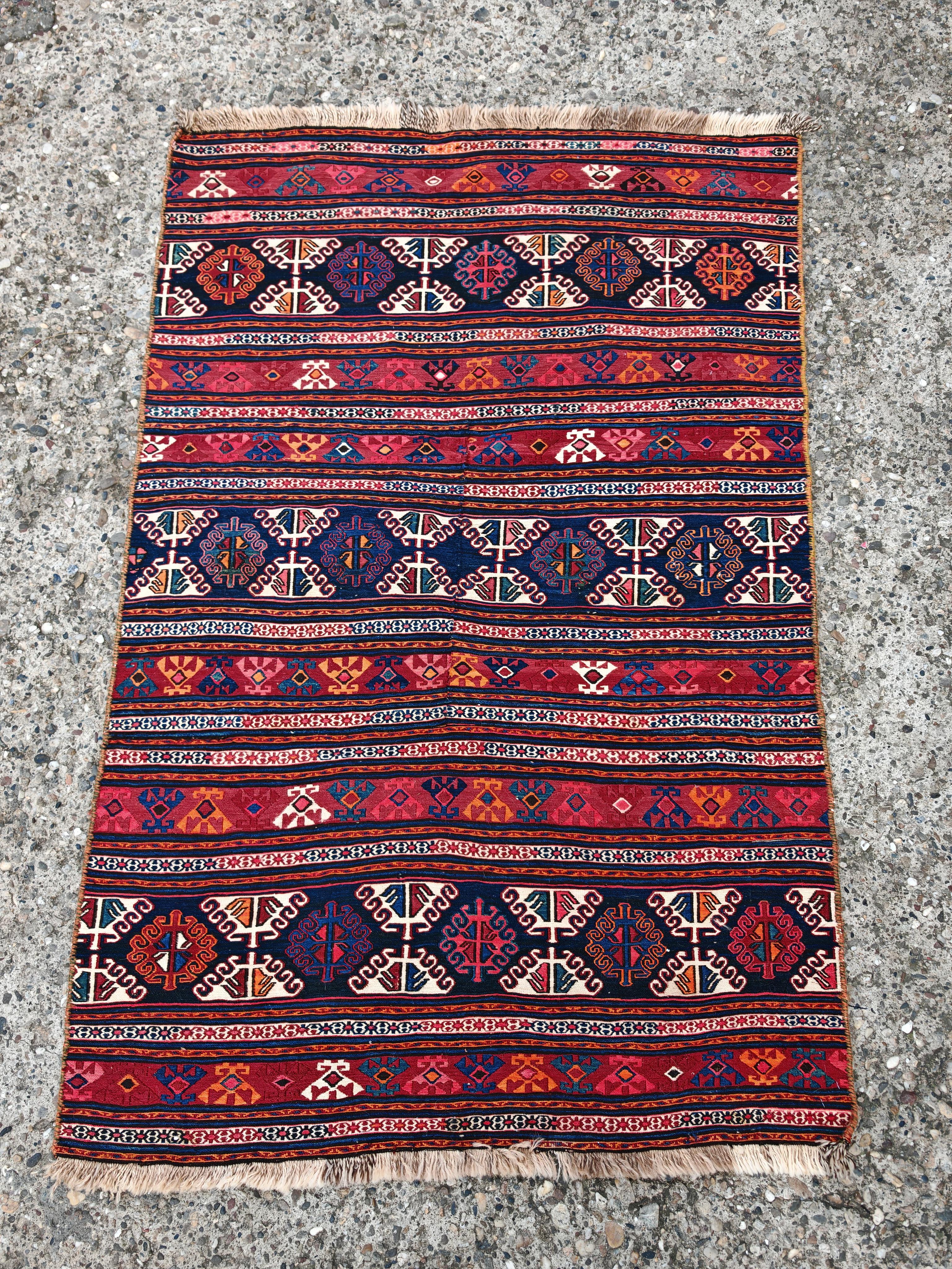 In diesem Angebot finden Sie einen wunderschönen kleinen antiken Schahsavan Kelim oder flachgewebten Teppich. Die verschlungenen geometrischen Muster sind charakteristisch für die Region. Der Teppich hat ein gestreiftes Muster mit sich