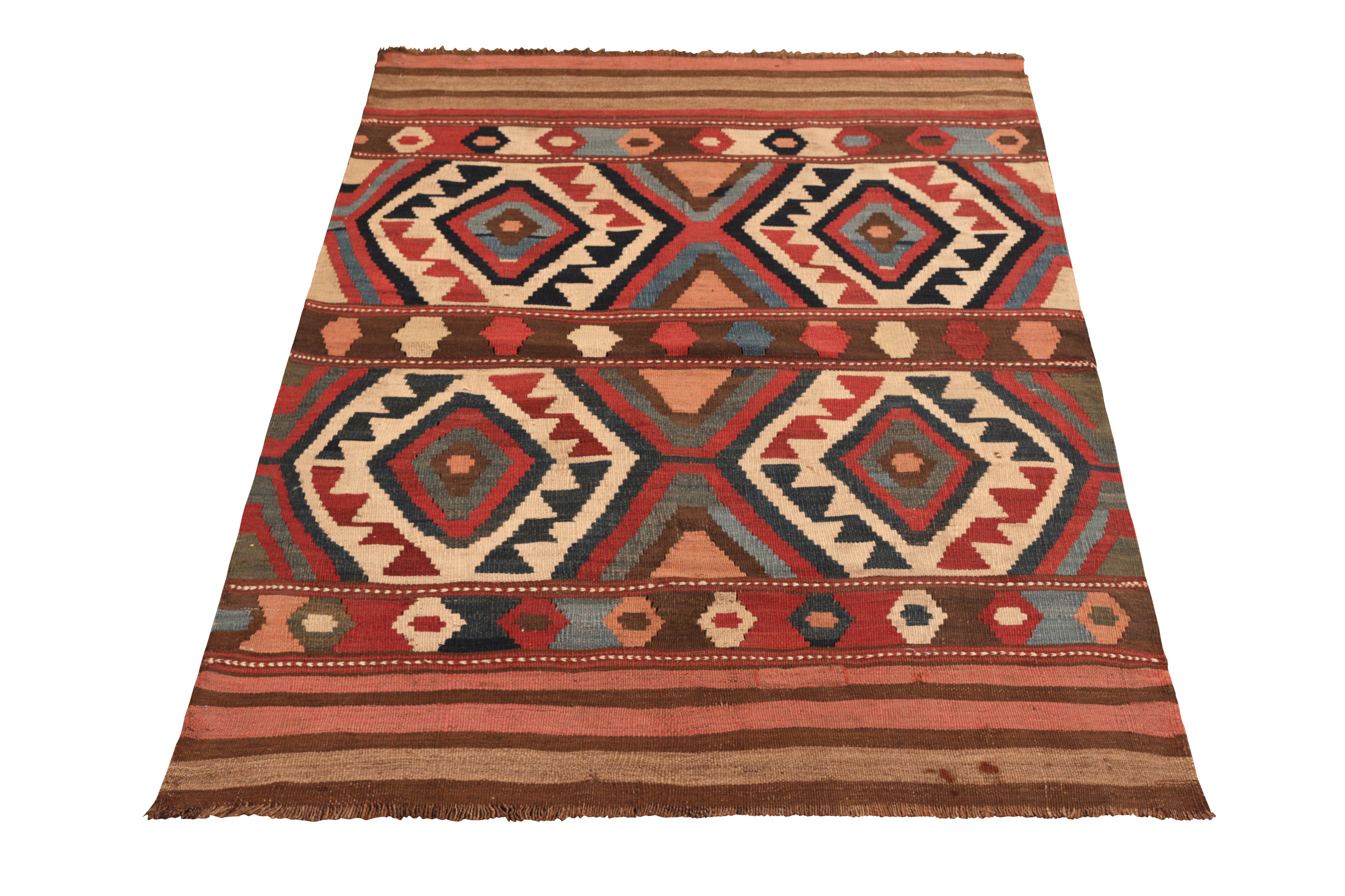 Hand woven in wool originating from Russia circa 1910-1920, this antique rug connotes a transitional Shahsavan Kilim with an arresting tribal pattern; hues of clay red, blue, black and off-white lending a sense of movement to the prevailing