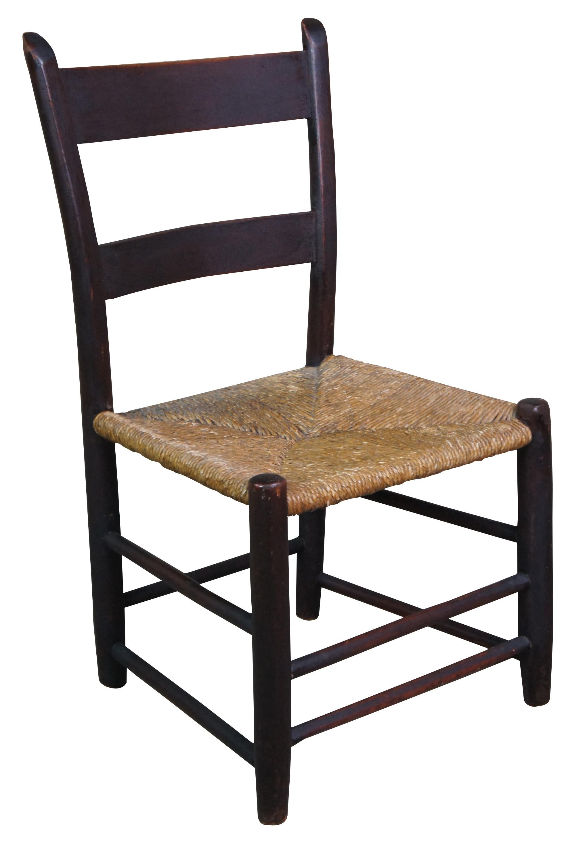 Antique Shaker child sized country farmhouse dining chair featuring ladder back and rush seat.
 