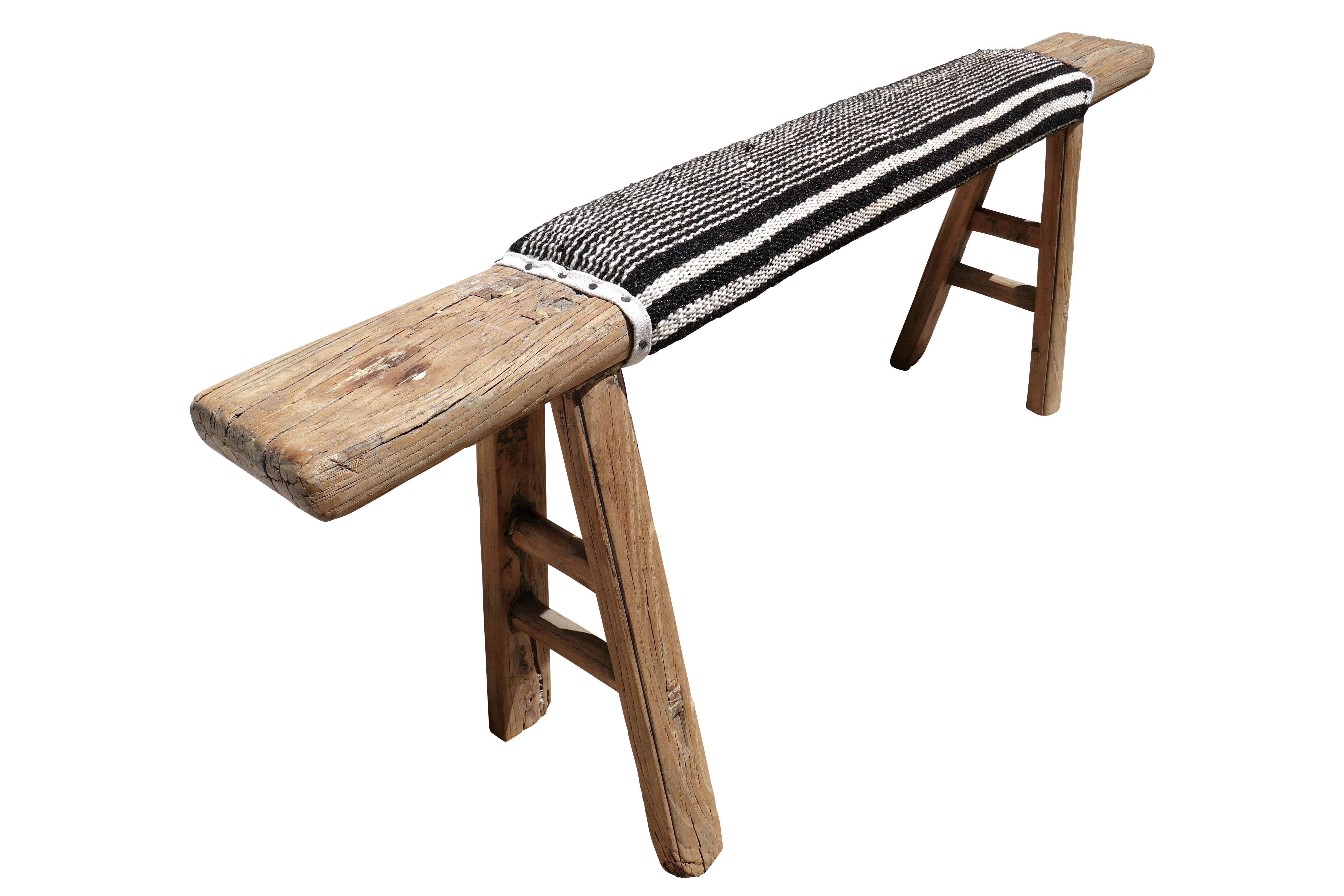 Antique Shandong elm bench. Primitively hand-built of solid elmwood, constructed with mortise & tenon joinery. Cushioned upholstered top in authentic Berber handwoven Kilim organic wool in black & natural color-way. Showing much desirable natural