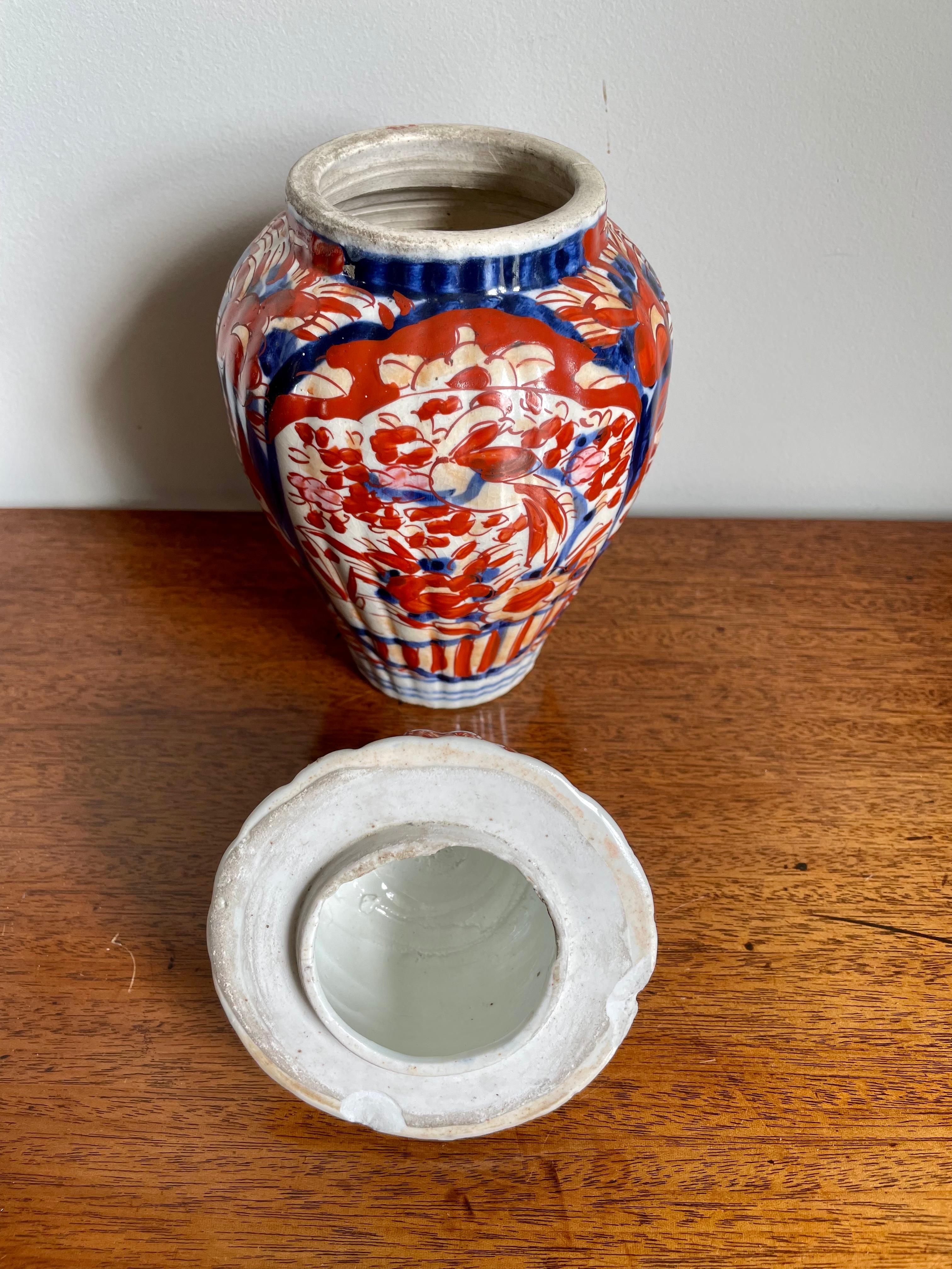 Antique vase imari de forme avec couvercle ayant un sommet en forme de fleuron et un couvercle en forme de dôme, vase de forme balustre avec une belle décoration peinte à la main dans de merveilleuses couleurs de rouge, bleu, blanc et or.

Une
