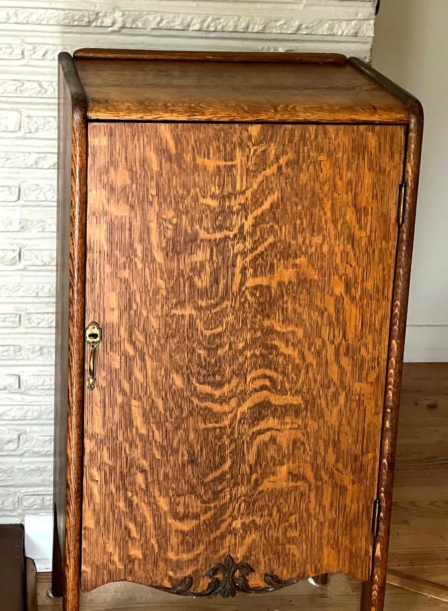 Ce meuble à partitions ancien présente une belle finition en chêne tigré, caractérisée par des motifs de grain distinctifs qui ressemblent à des rayures ou à des marques de 