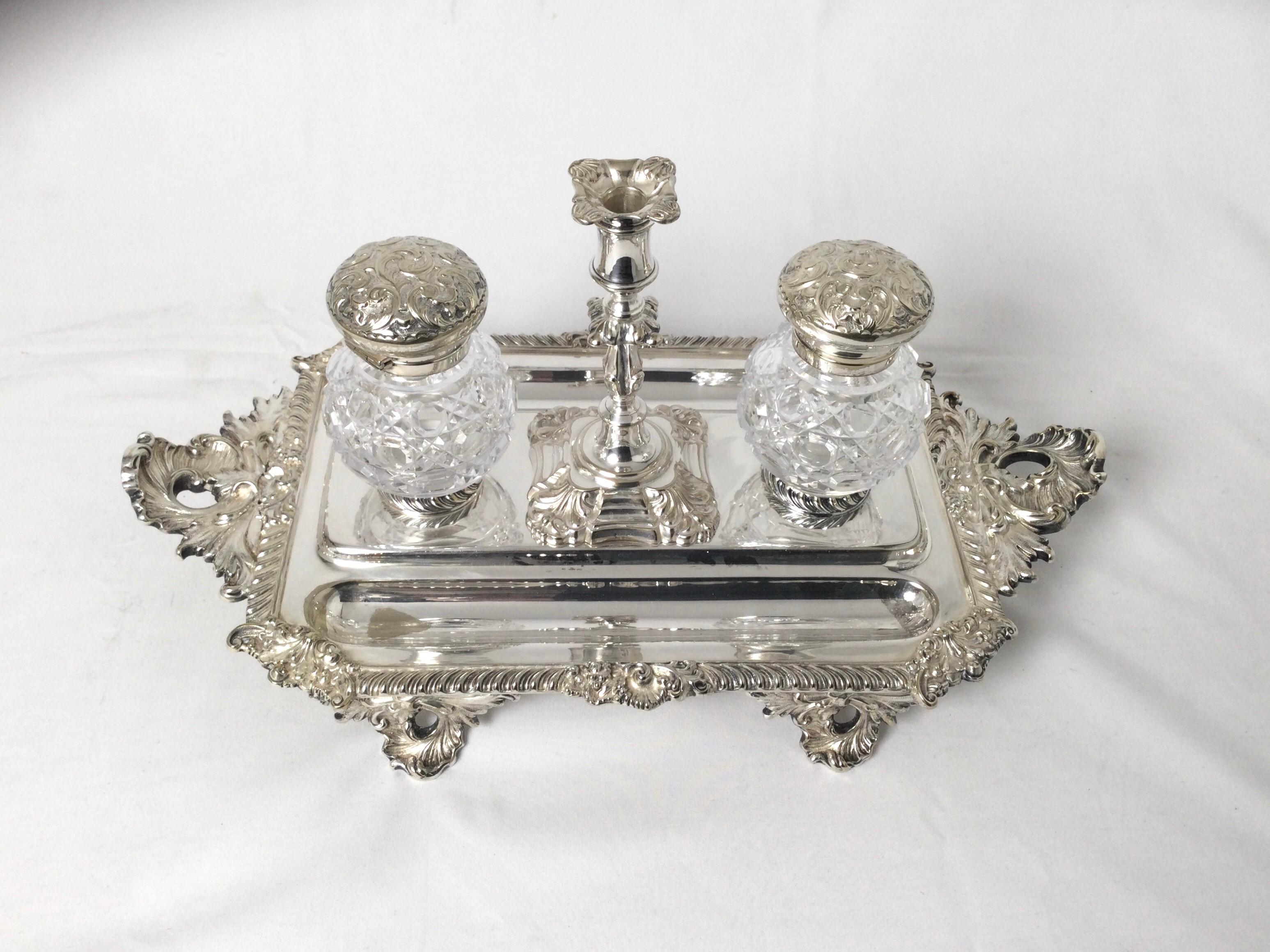 Beautiful Sheffield silver plated and cut glass double inkwell. The cut glass round inkwells with a Russian pattern with repousse hinged lids fit neatly onto the base which has a miniature candlestick with original bobeche.
