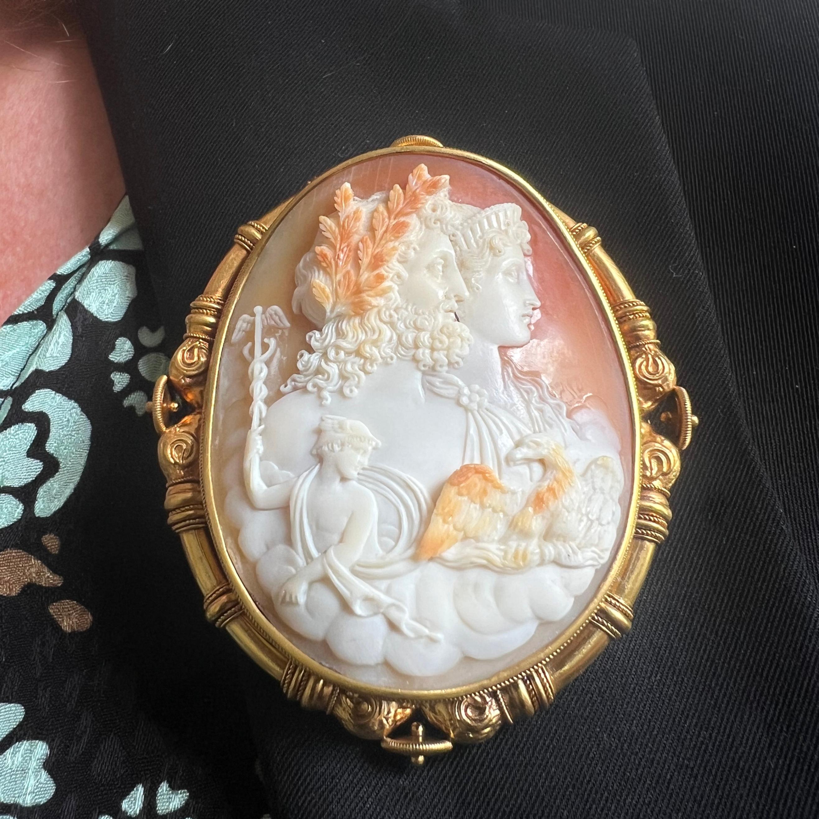 An antique shell cameo and gold brooch, featuring a conch shell cameo, carved with figures representing the Roman god Jupiter or the Greek god Zeus, with his eagle symbol and the Roman goddess Juno or the Greek goddess Hera, with a smaller carving