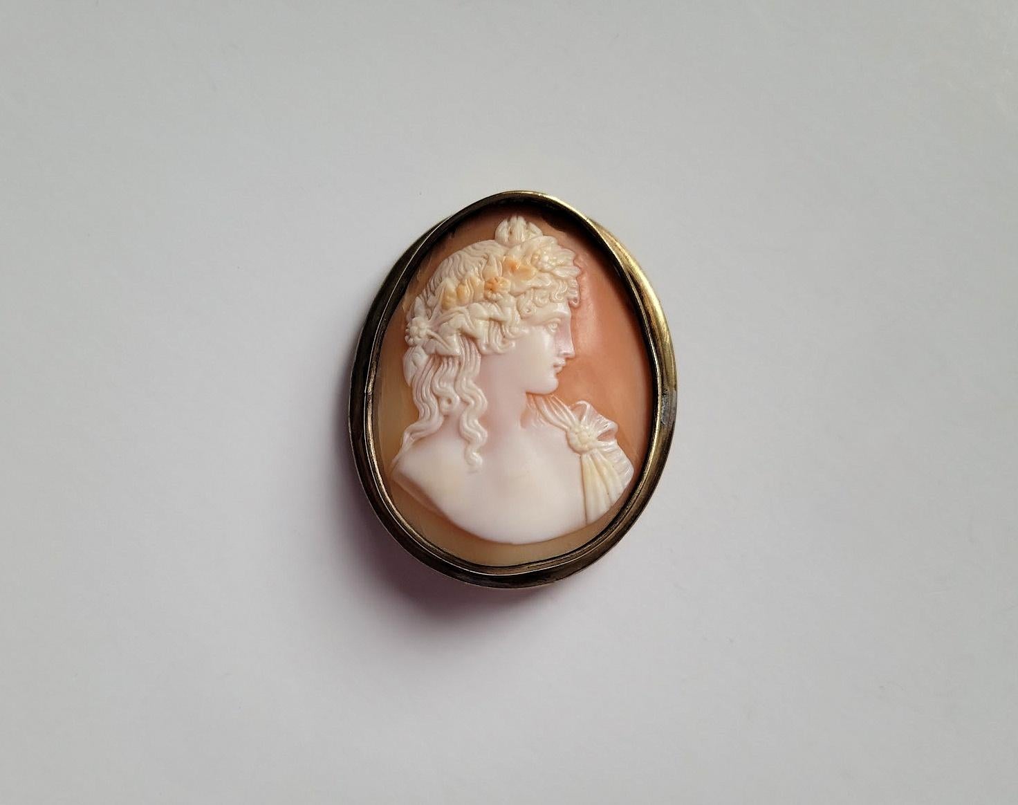 Antique sardonyx shell cameo circa 1870. The subject is Antinous, the favorite of Emperor Hadrian, a handsome youth who was idealized as an example of perfect male beauty. He is depicted in profile with a pine cone, the symbol of fertility, and