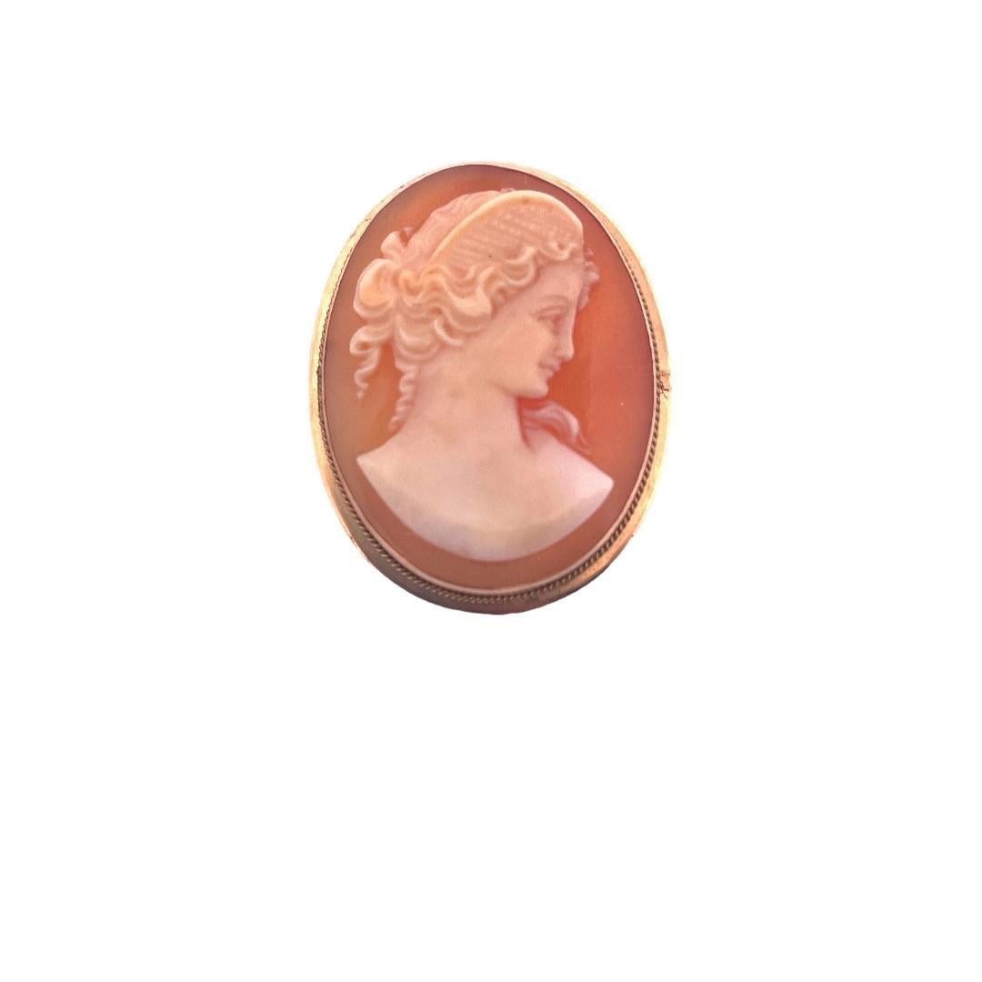 Unearth timeless beauty with this elegant antique Shell Cameo Brooch. Crafted in exquisite 14K yellow gold and weighing 4.4 grams,
this brooch showcases a delicate and meticulously carved shell cameo that is a true work of art.

Material: 12K yellow